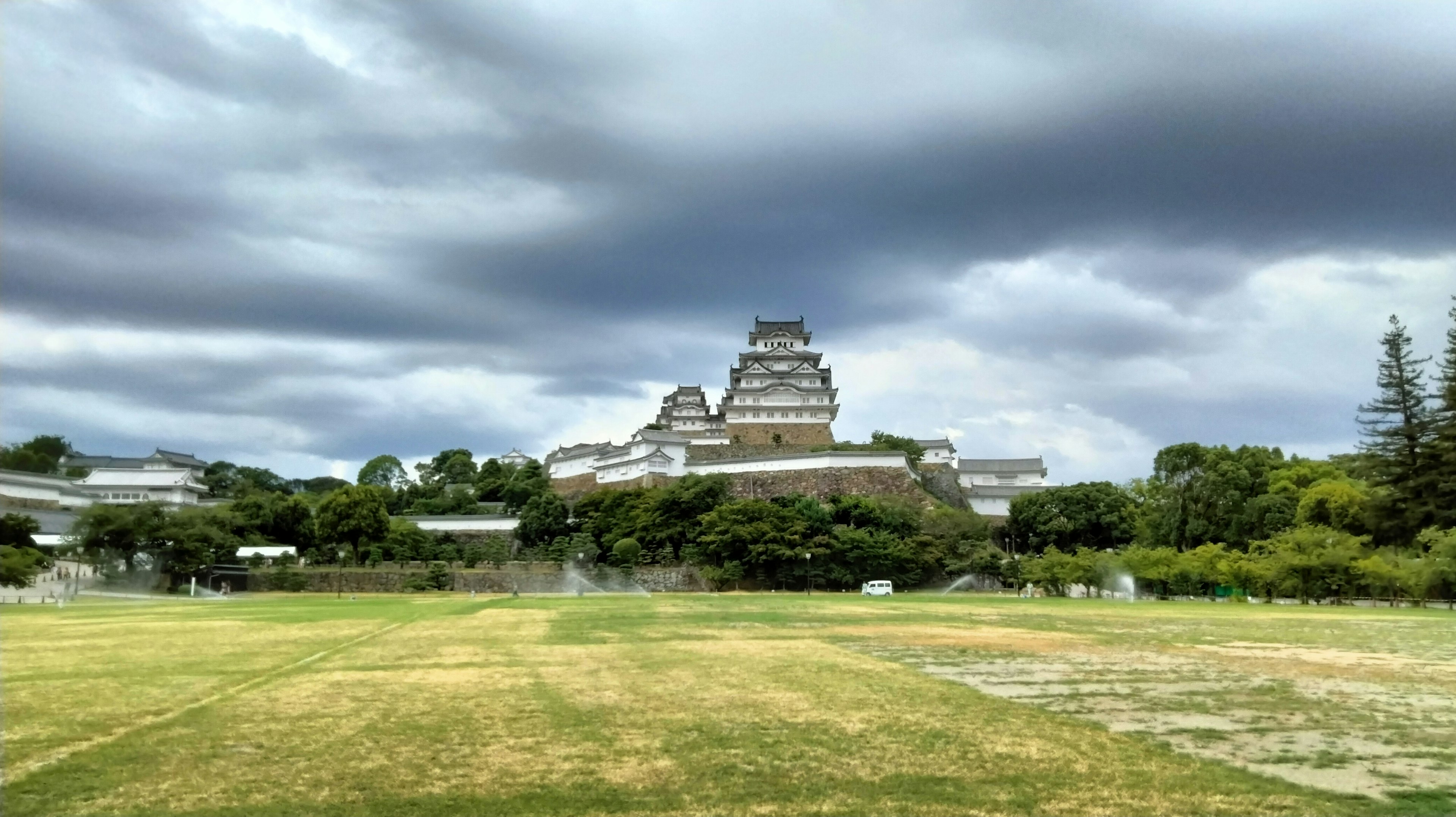 A beautiful castle surrounded by greenery and a wide grassy area