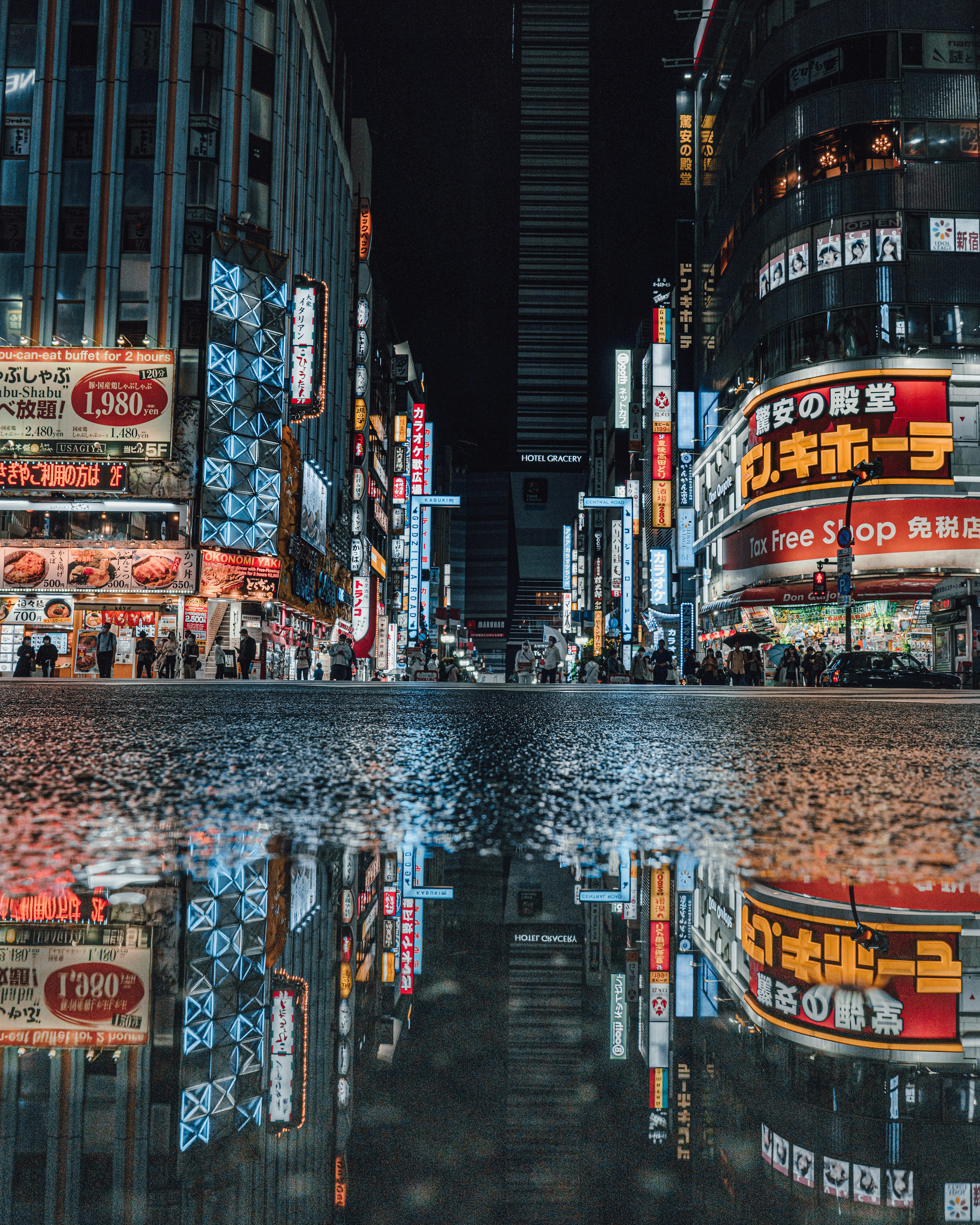 夜の街並みの反射が印象的な繁華街の風景