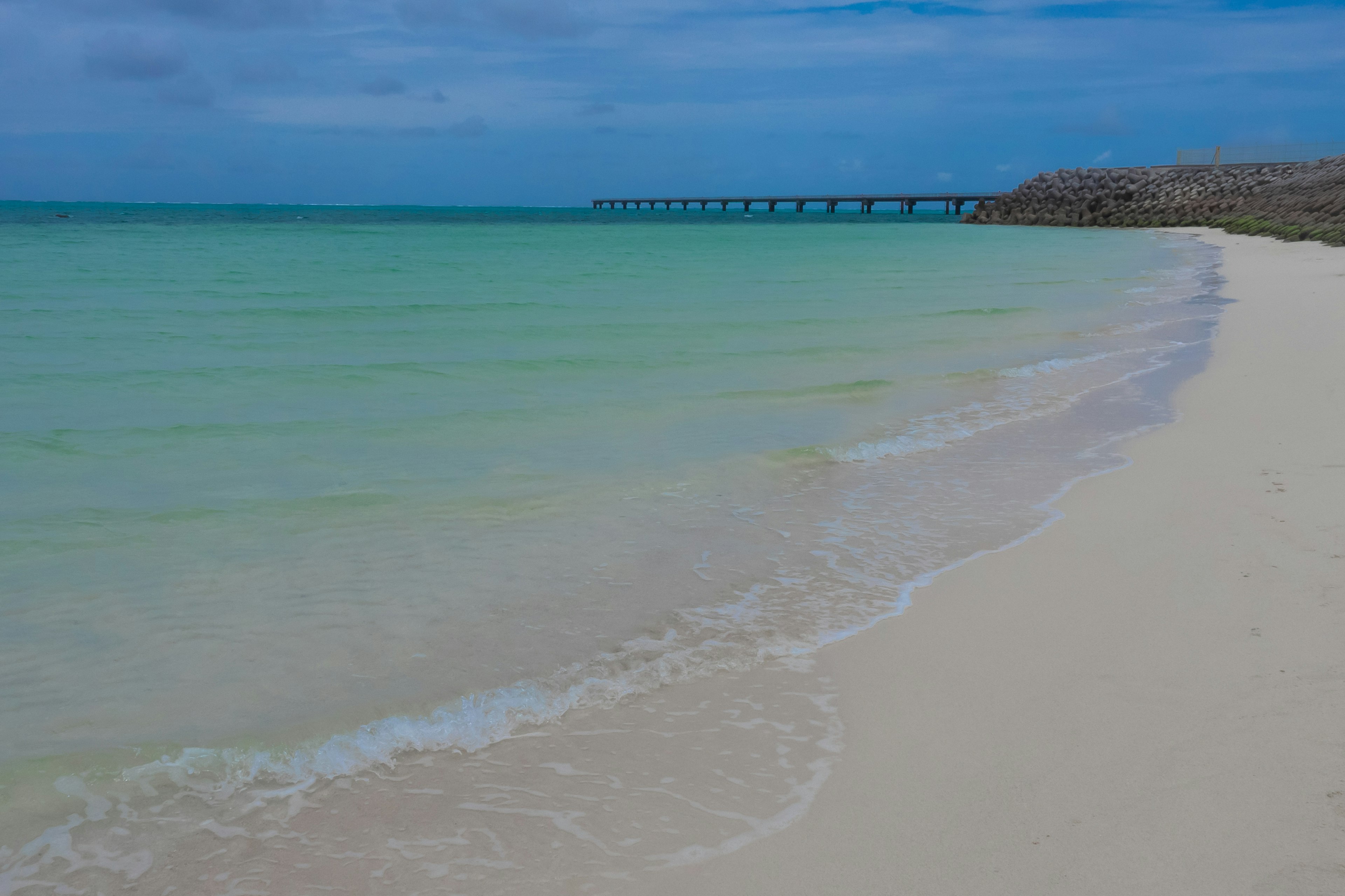 Strandansicht mit klarem blauen Wasser und weißem Sand