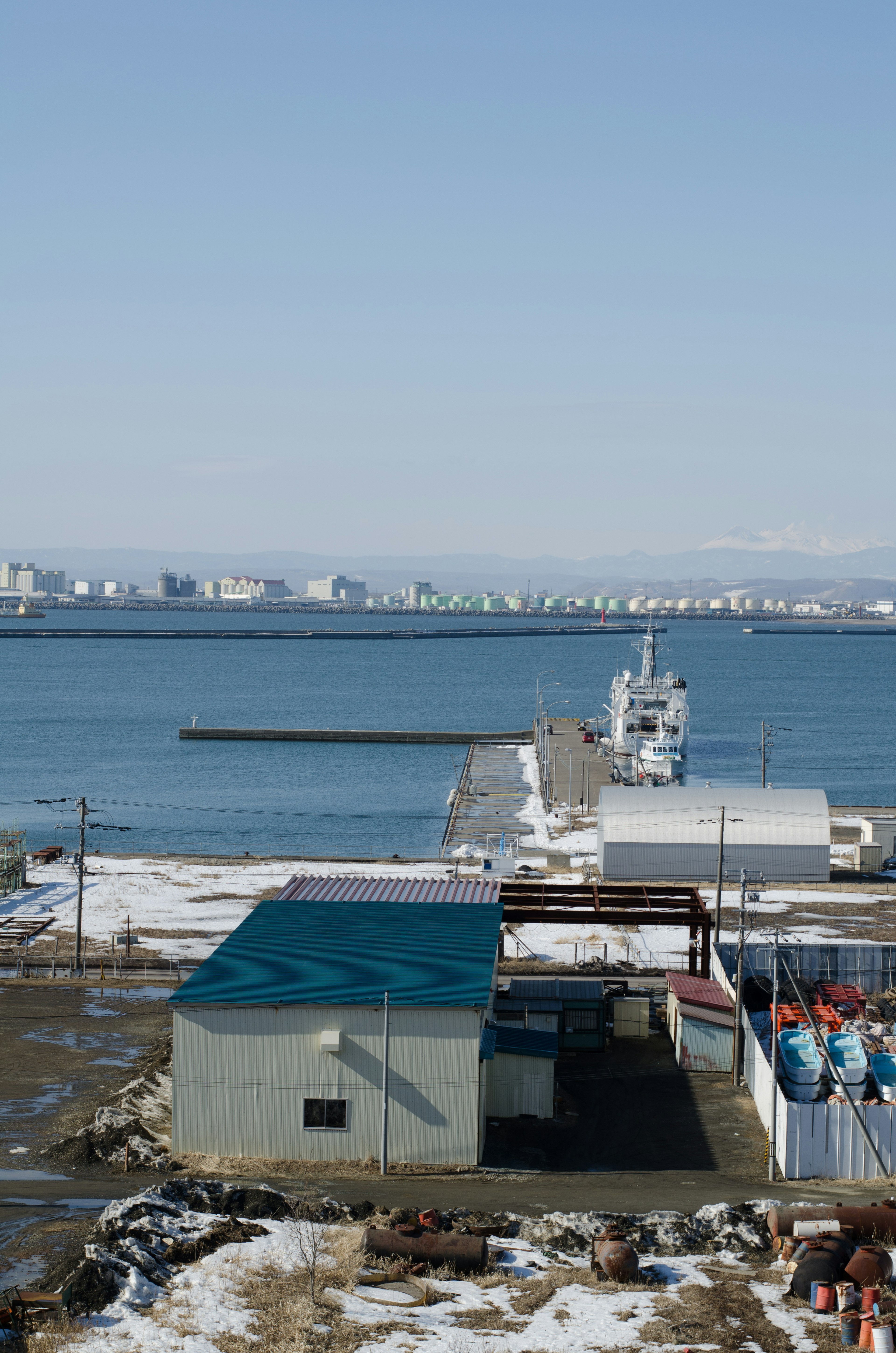 View of a harbor with snow-covered ground boats and buildings visible