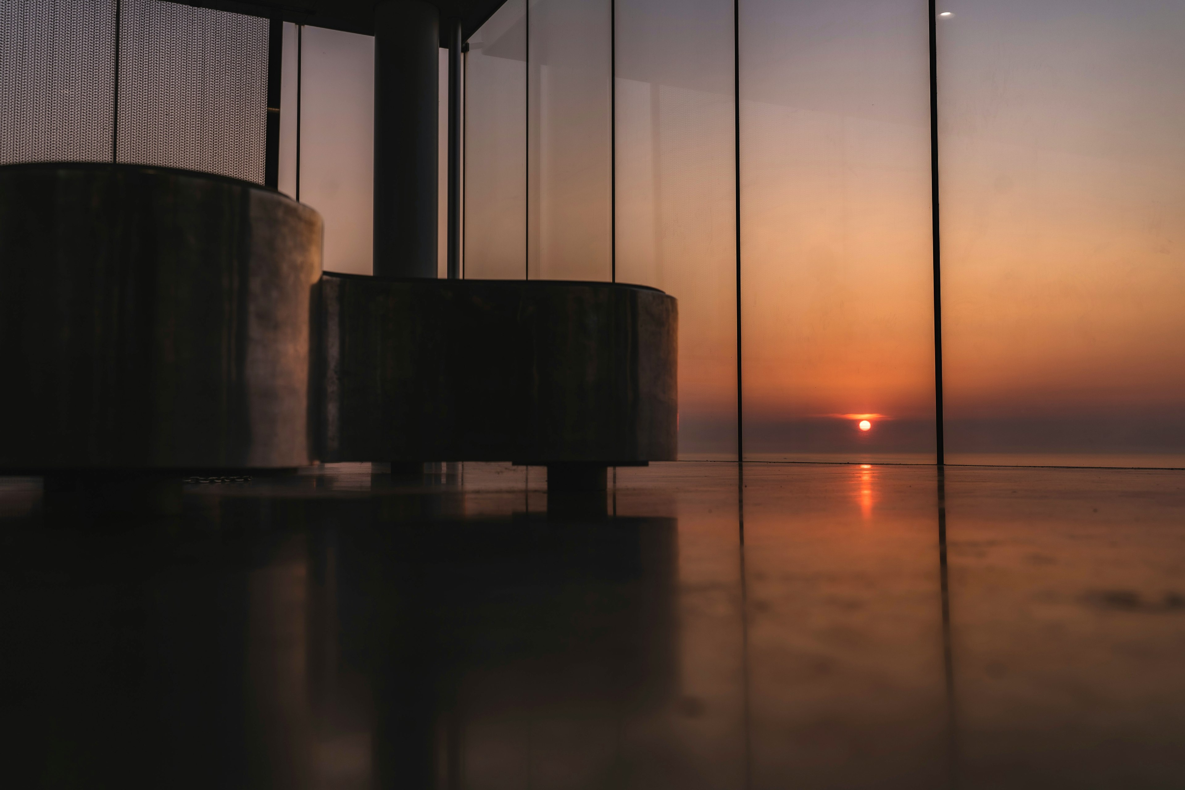 Beautiful sunset over the ocean with nearby cylindrical structures