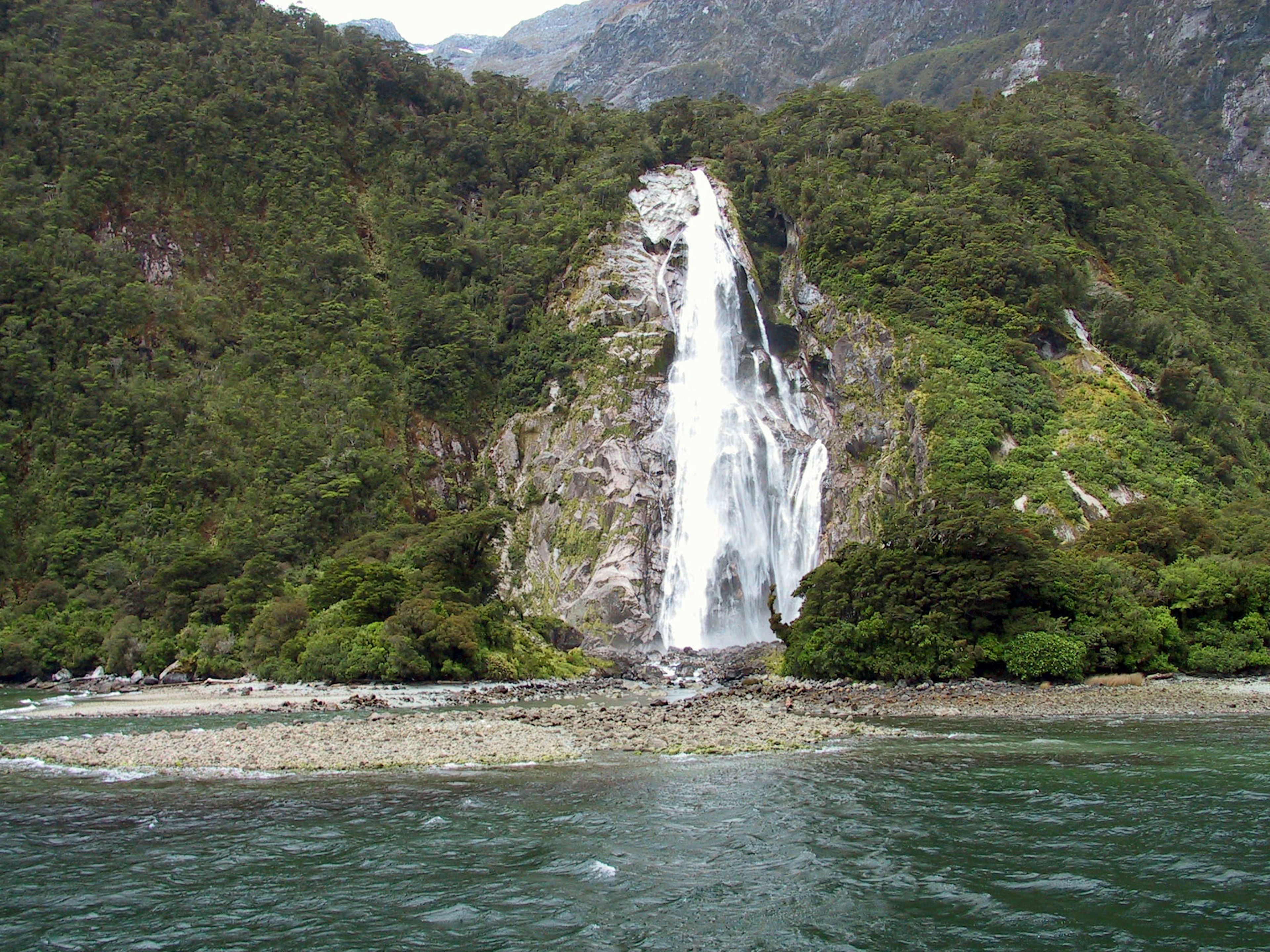 A waterfall cascading down a lush green mountain