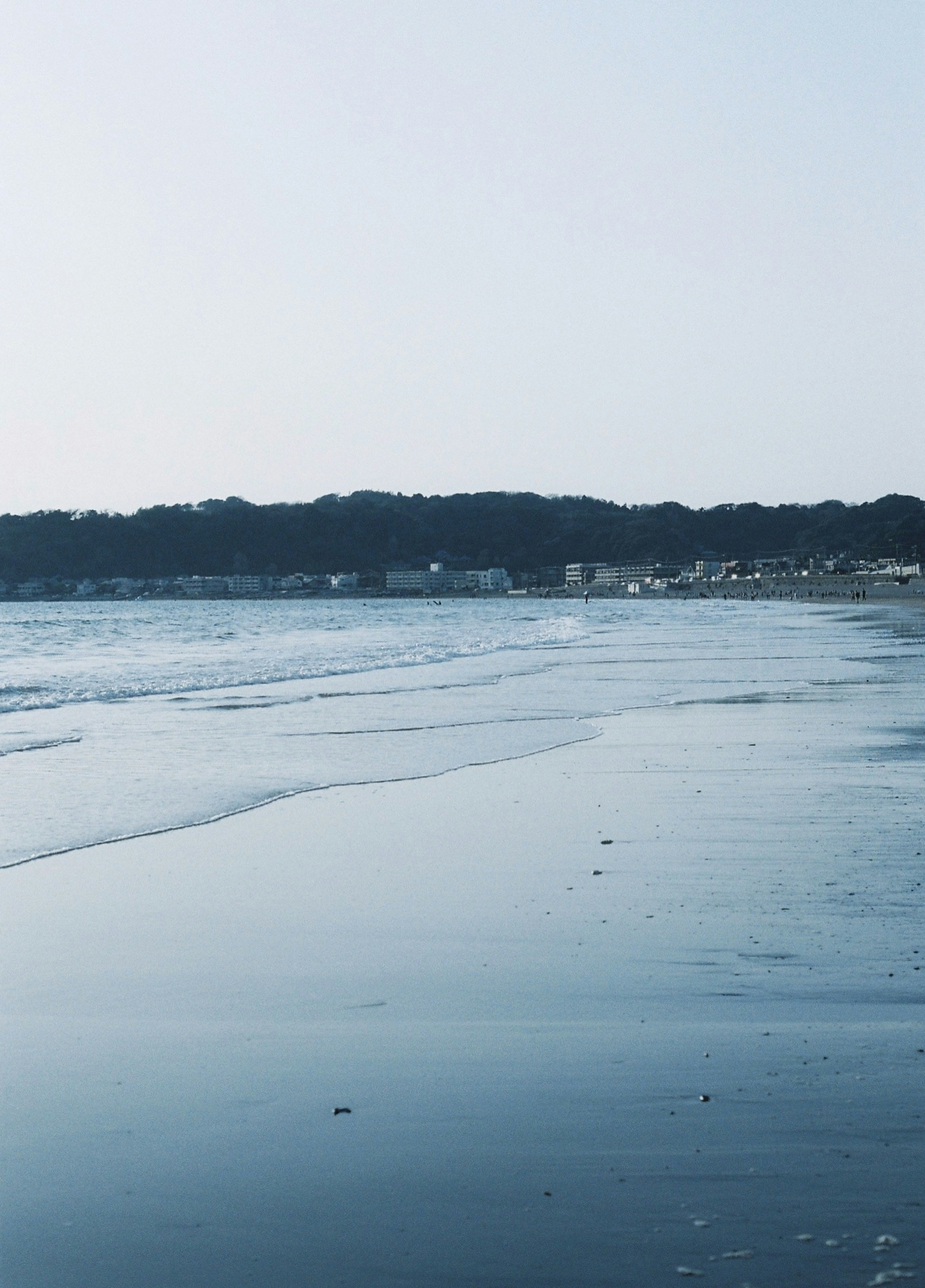 Scène de plage calme avec un ciel bleu vagues douces sur le rivage