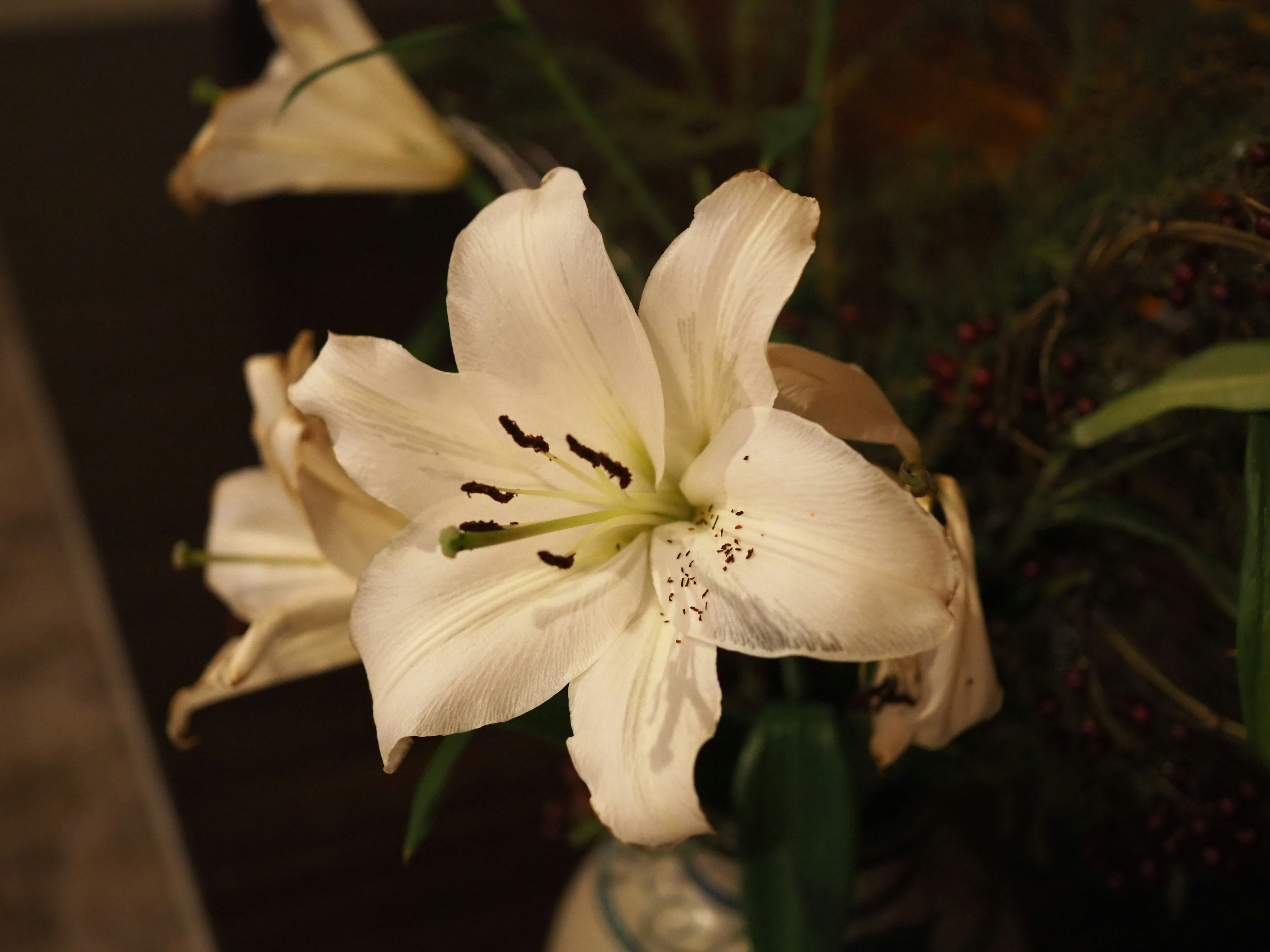 A white lily flower in a decorative vase arrangement