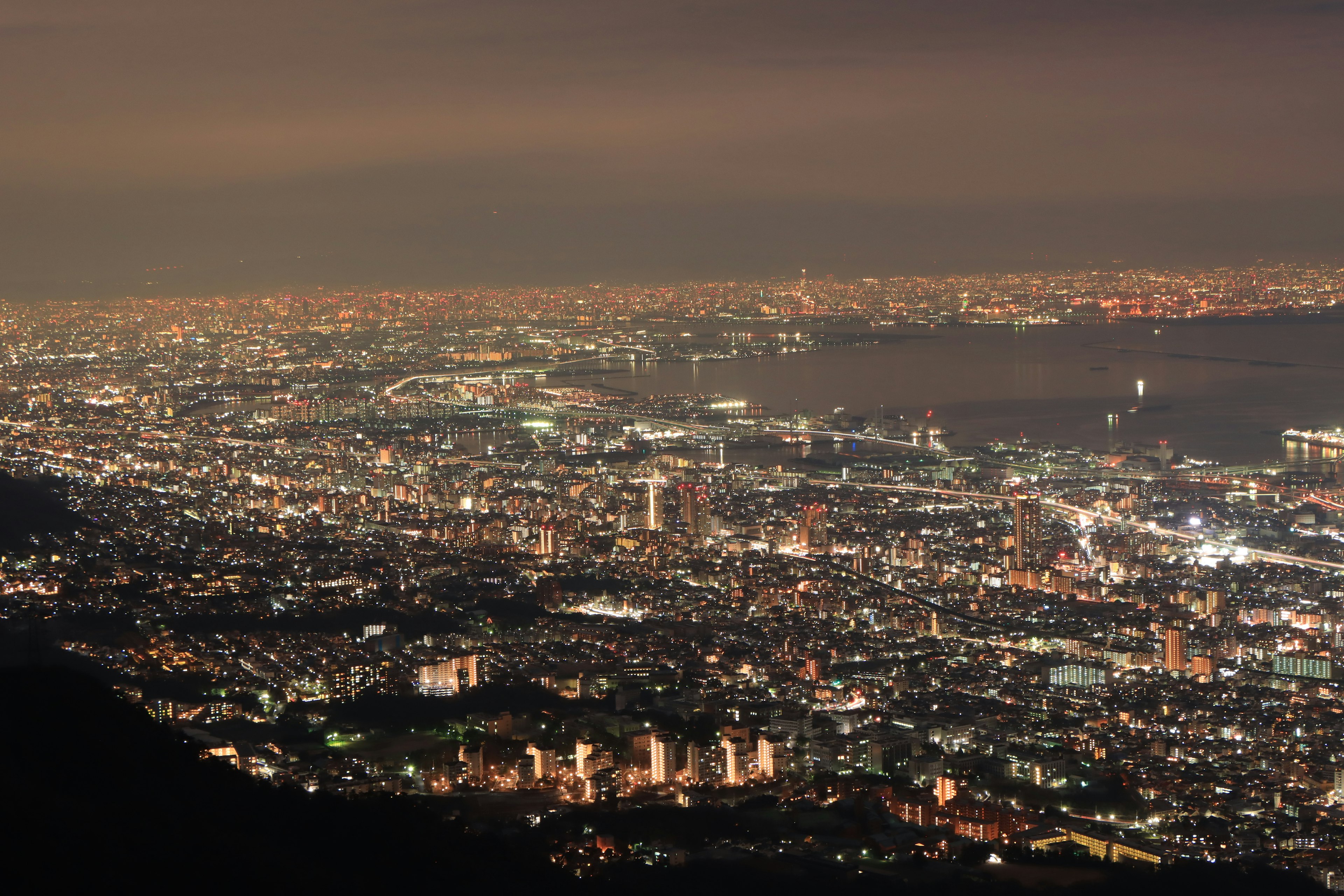 Paisaje urbano nocturno con edificios iluminados y puerto