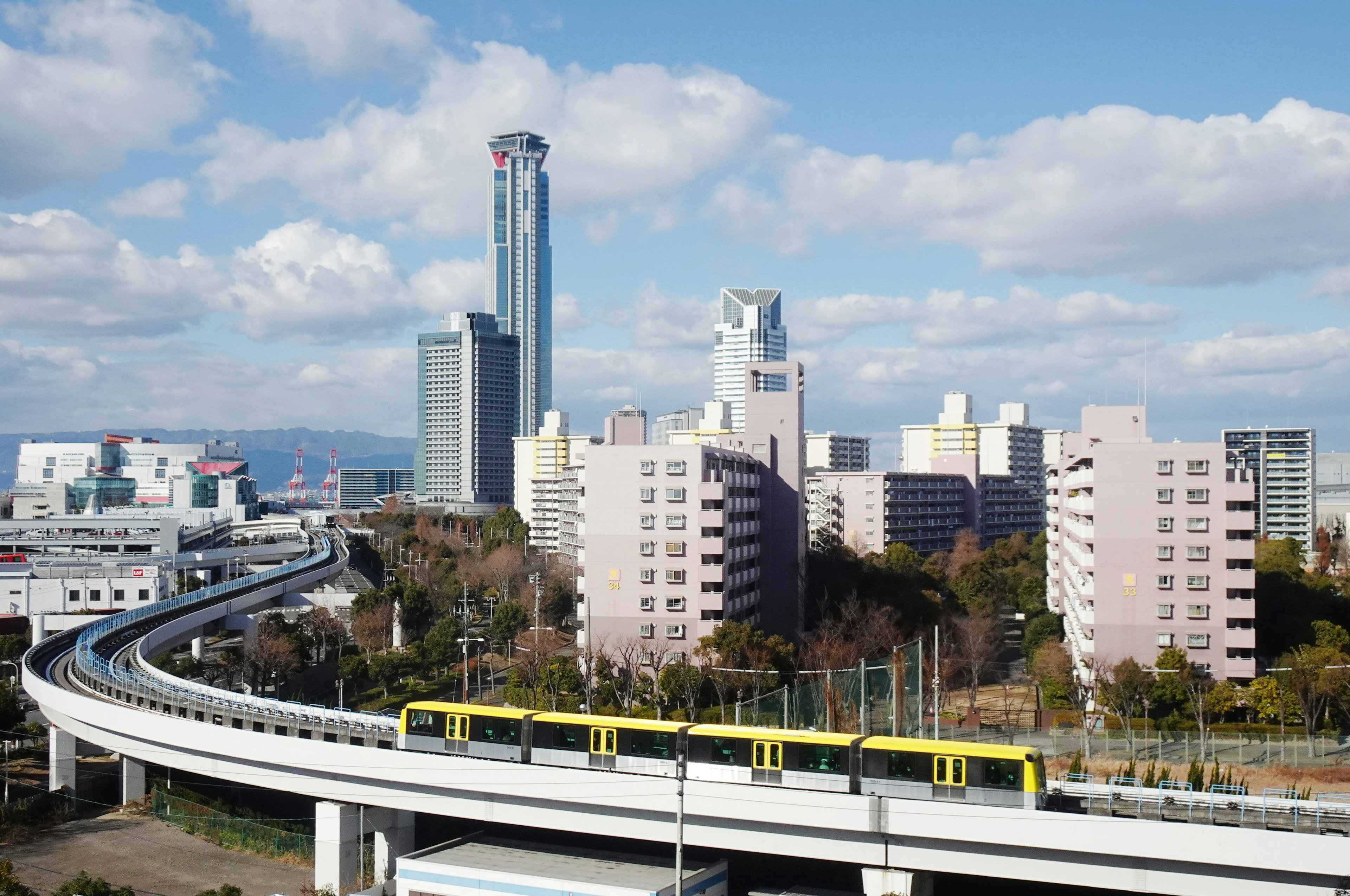 Urban landscape featuring a train on an elevated track and skyscrapers