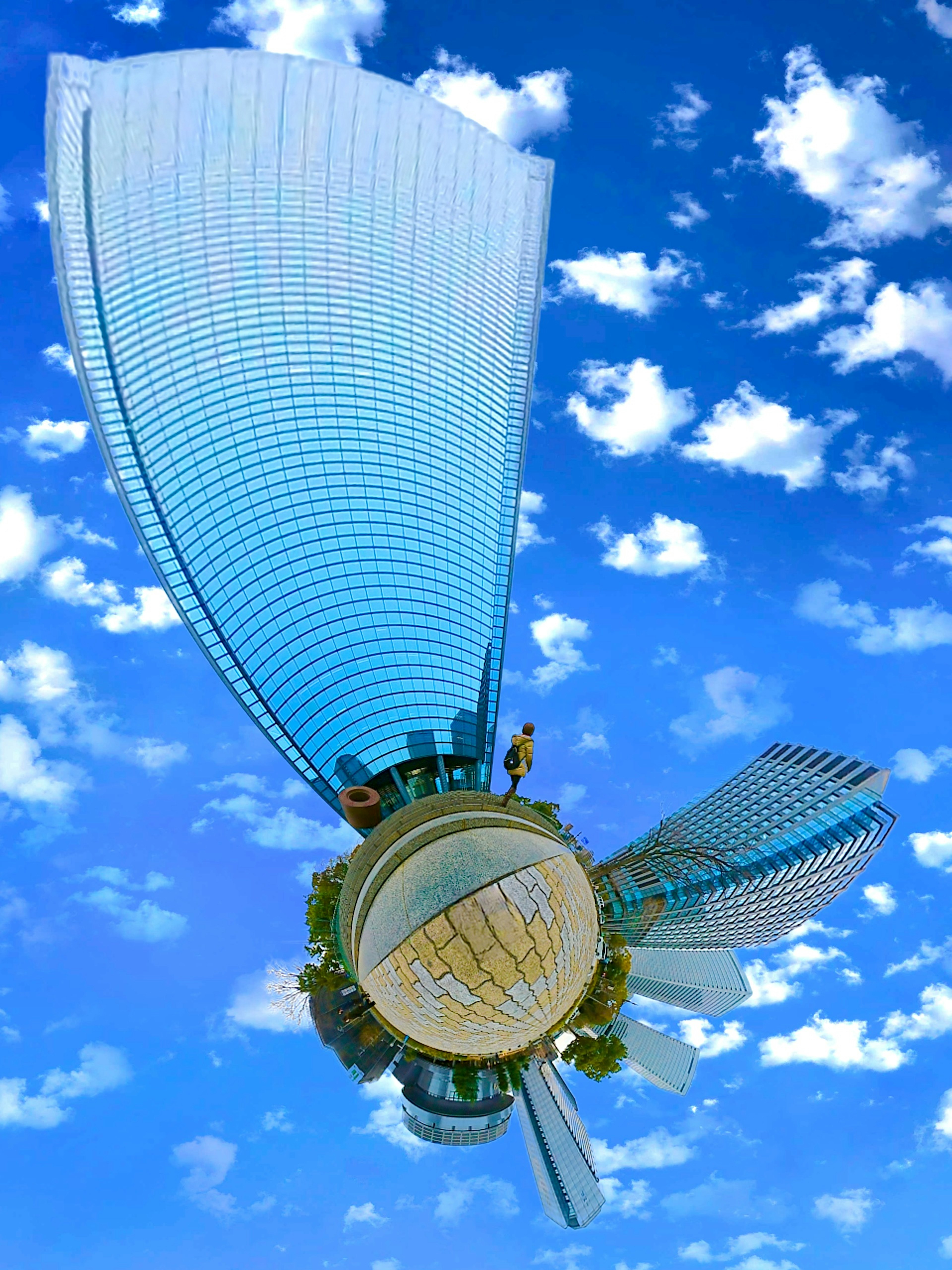 Modern sculpture with transparent wings under a blue sky