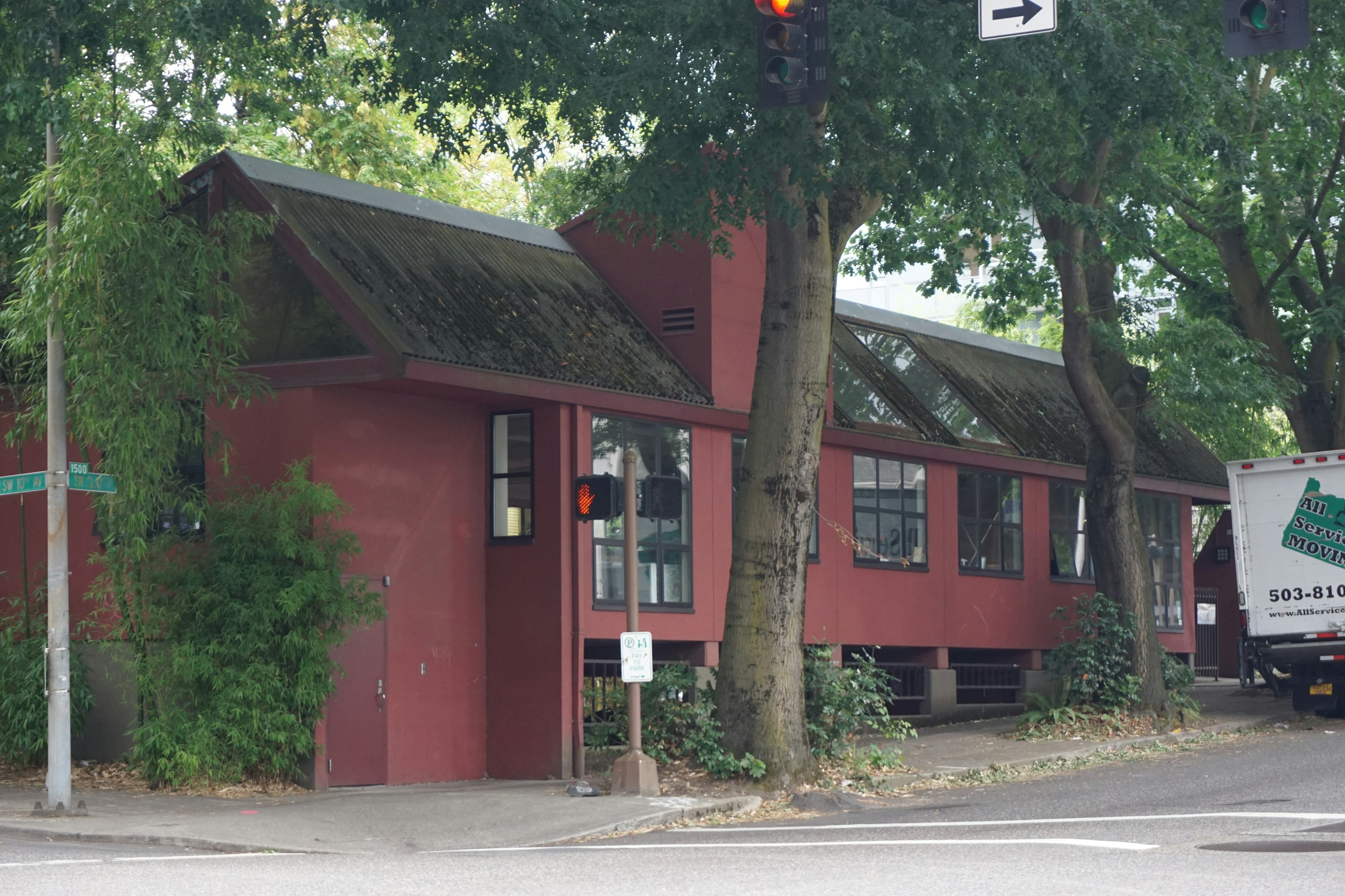 Unique building with red exterior and green trees