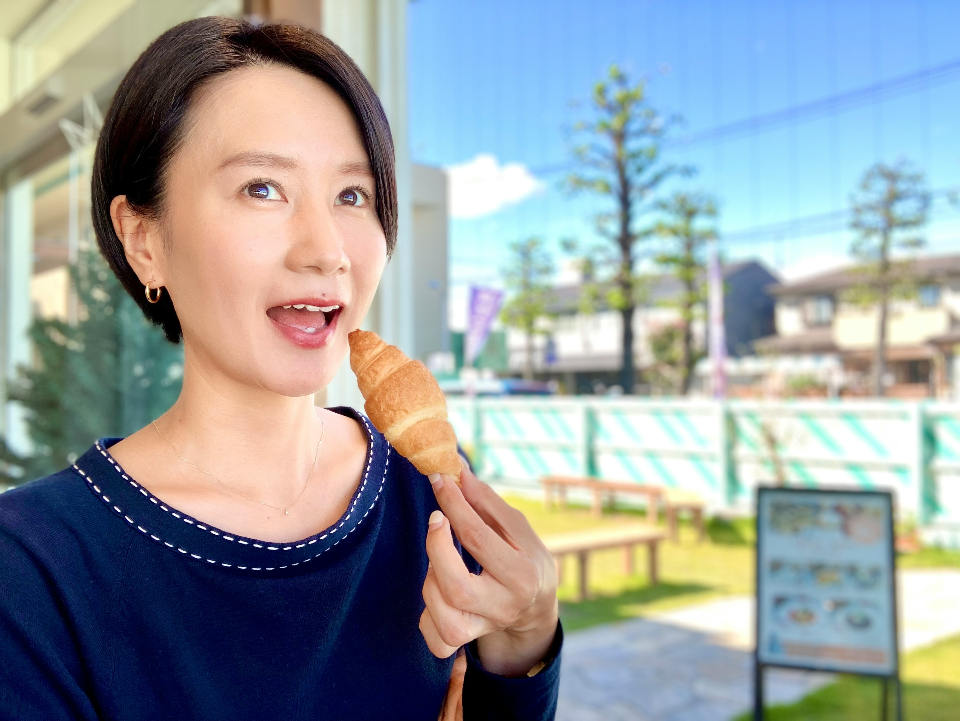 A woman smiling while holding ice cream in a cafe setting