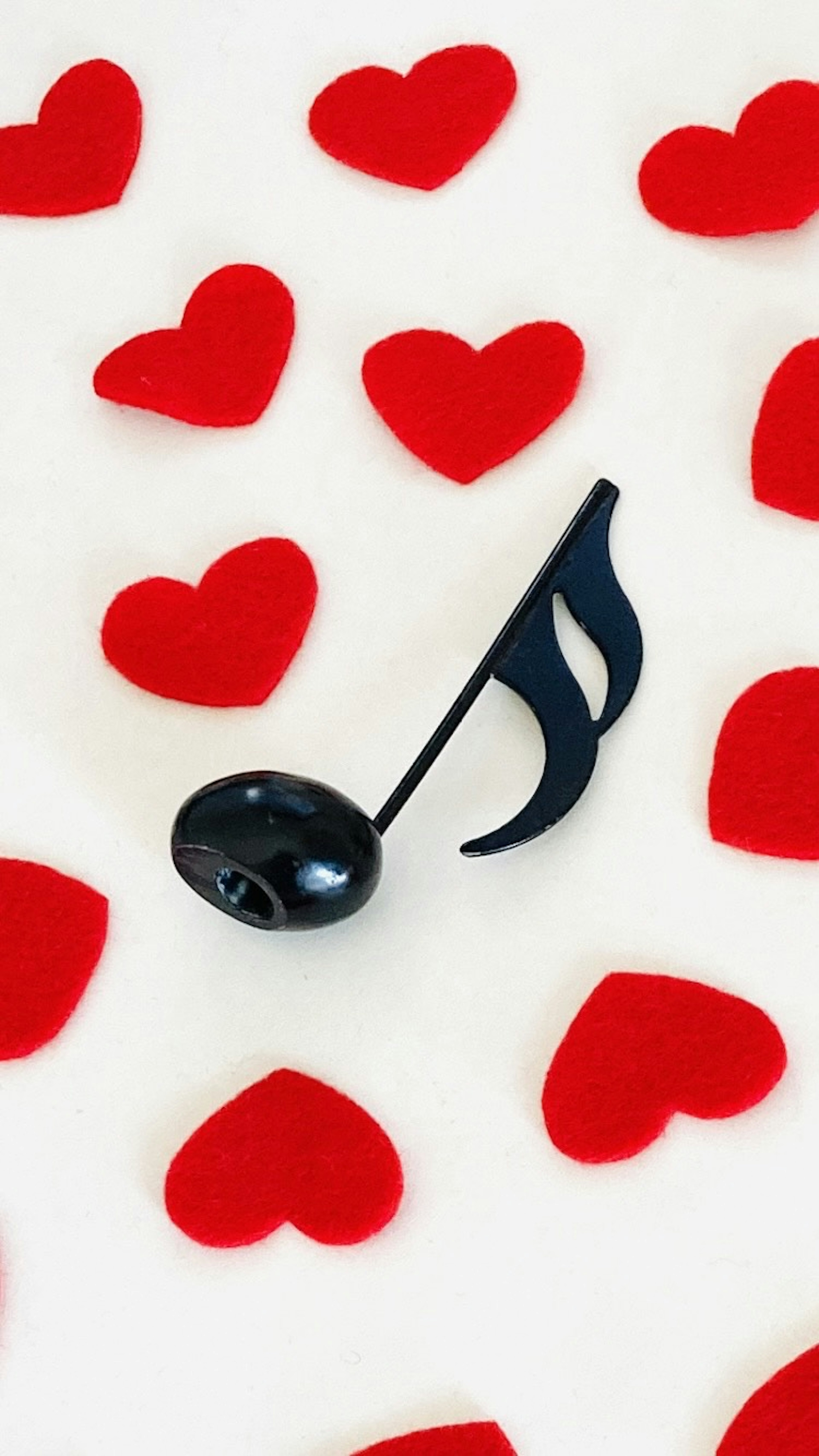 Black musical note surrounded by red hearts