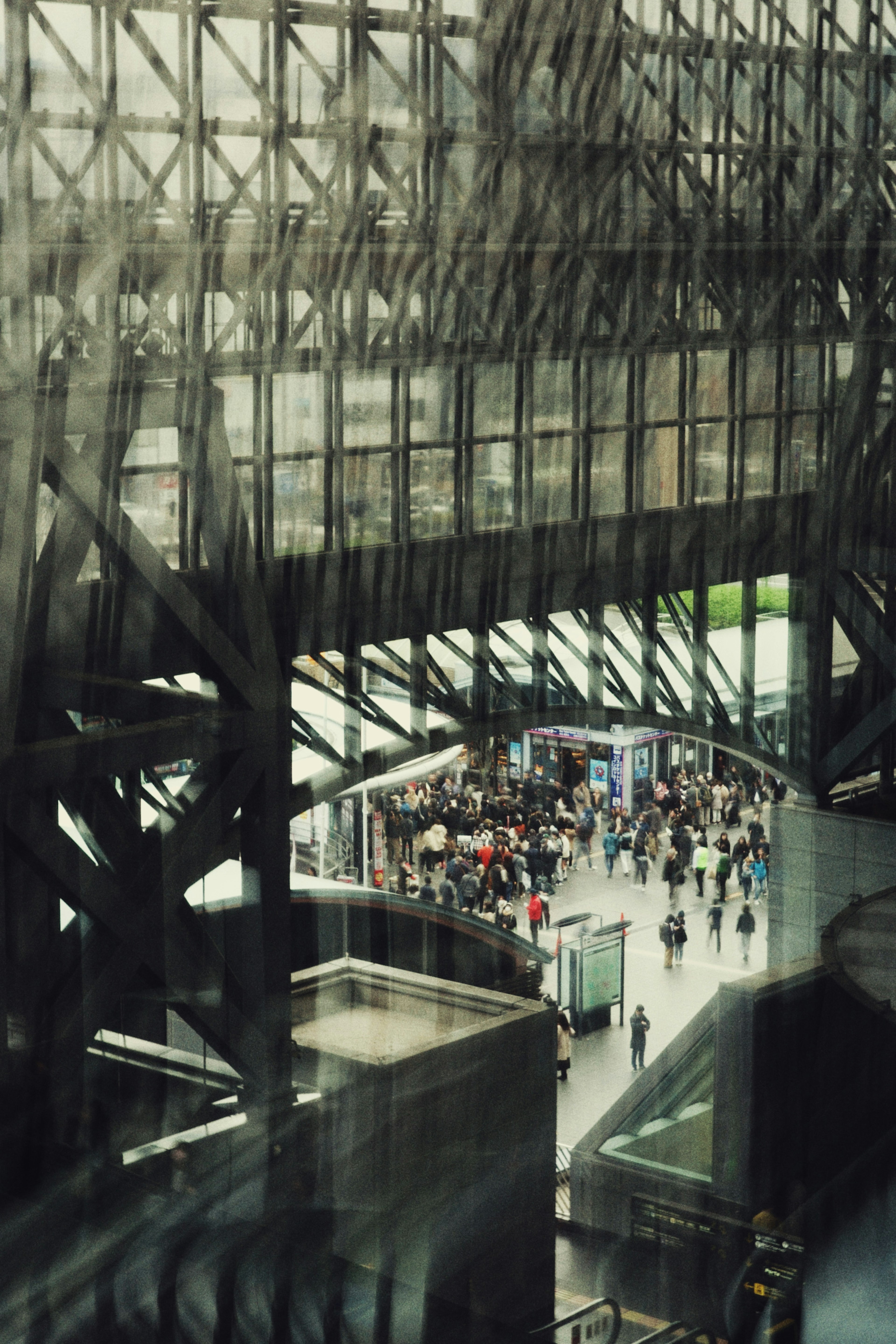 Interior of a glass and steel structure with people gathered below