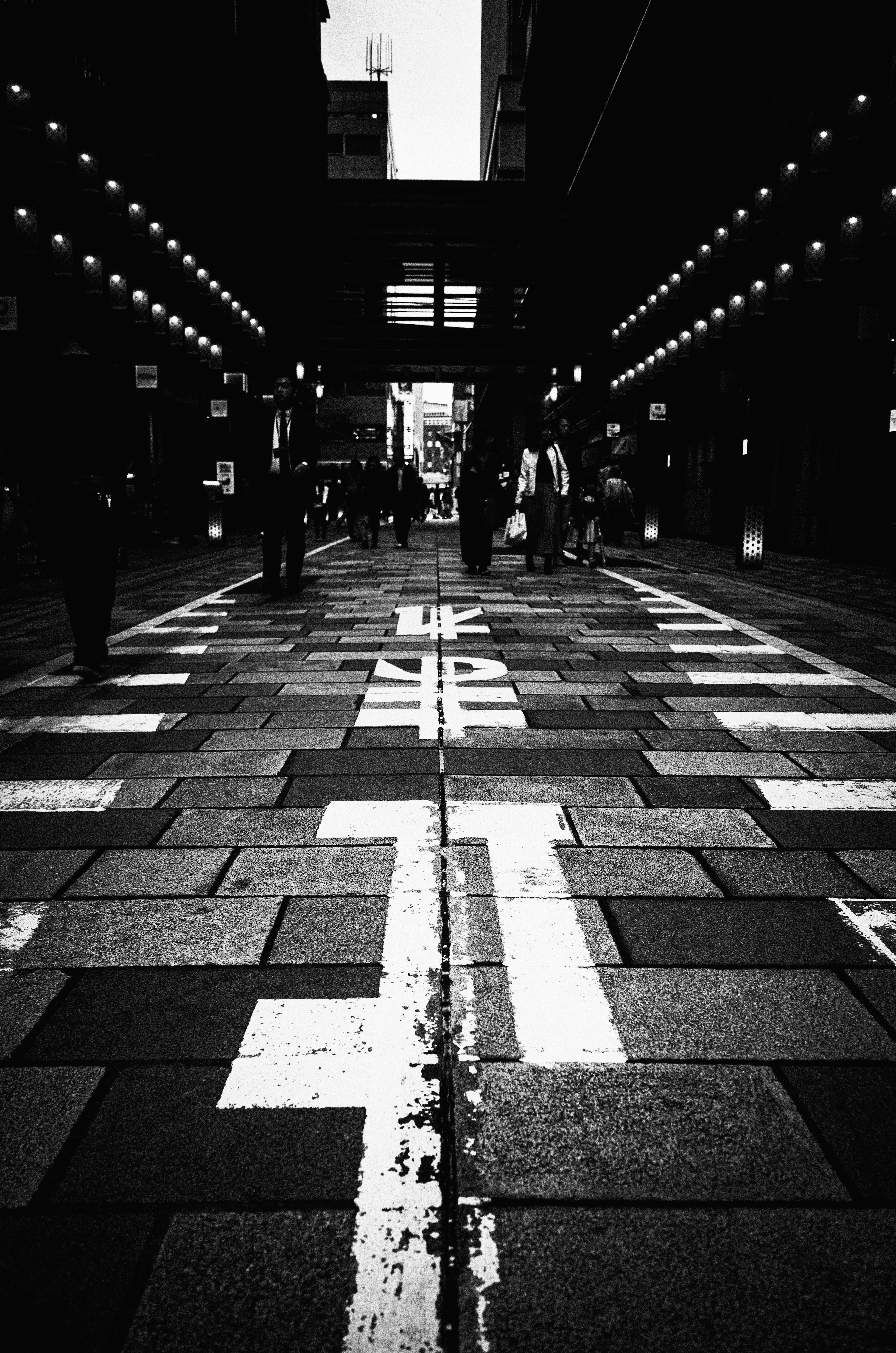 Black and white street scene showing people walking