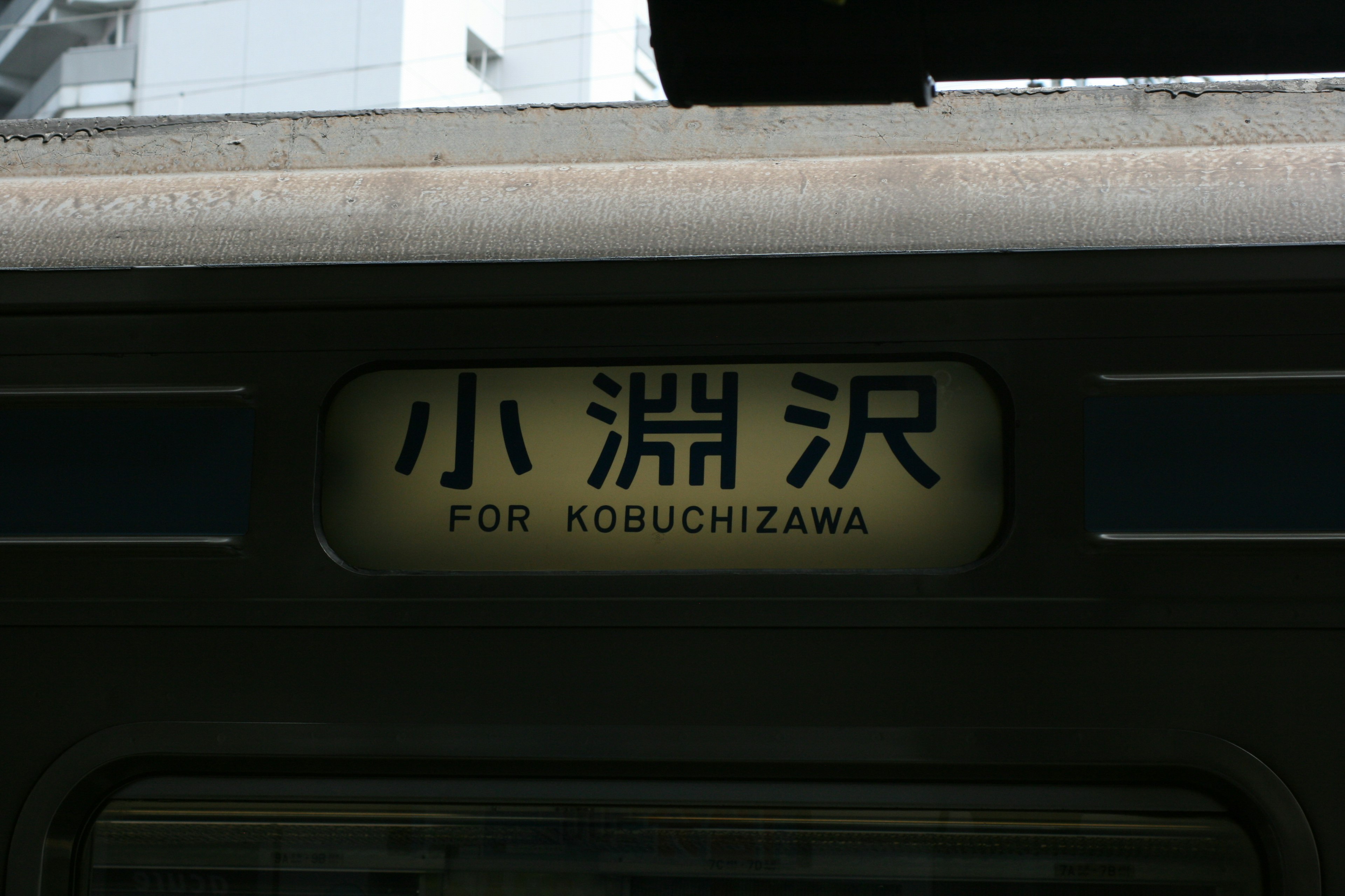 Interior view of a train featuring the sign for Kobuchizawa Station