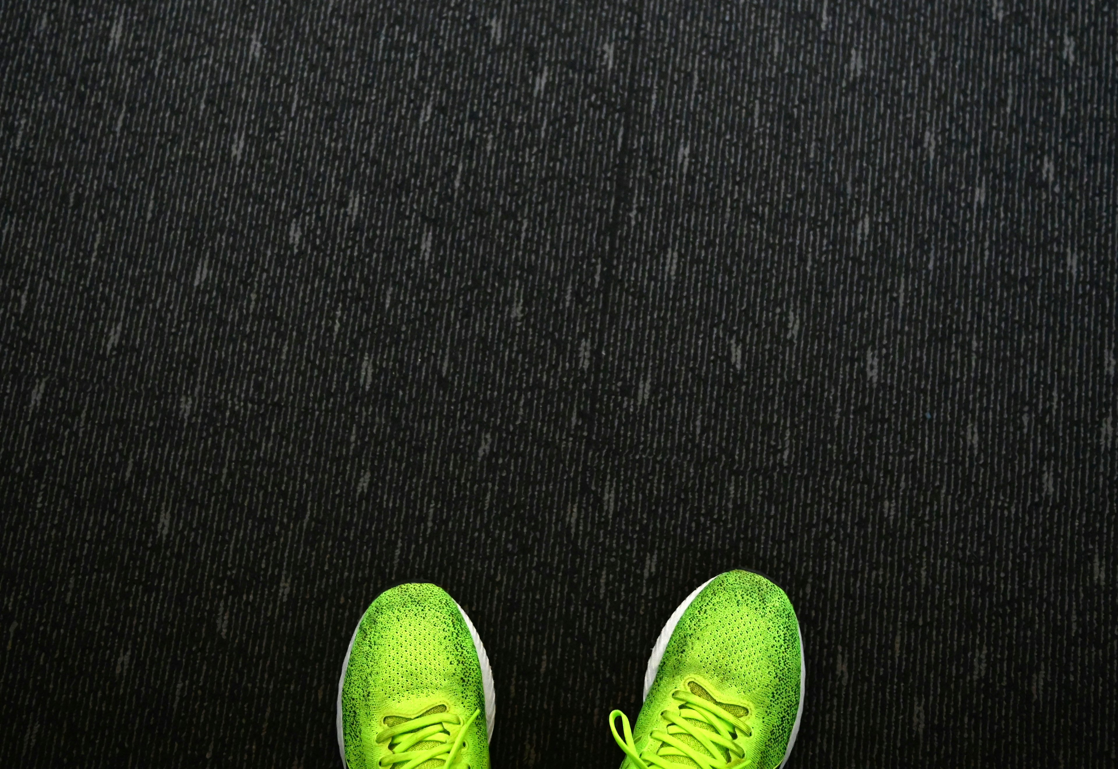 Green sneakers placed on a black floor