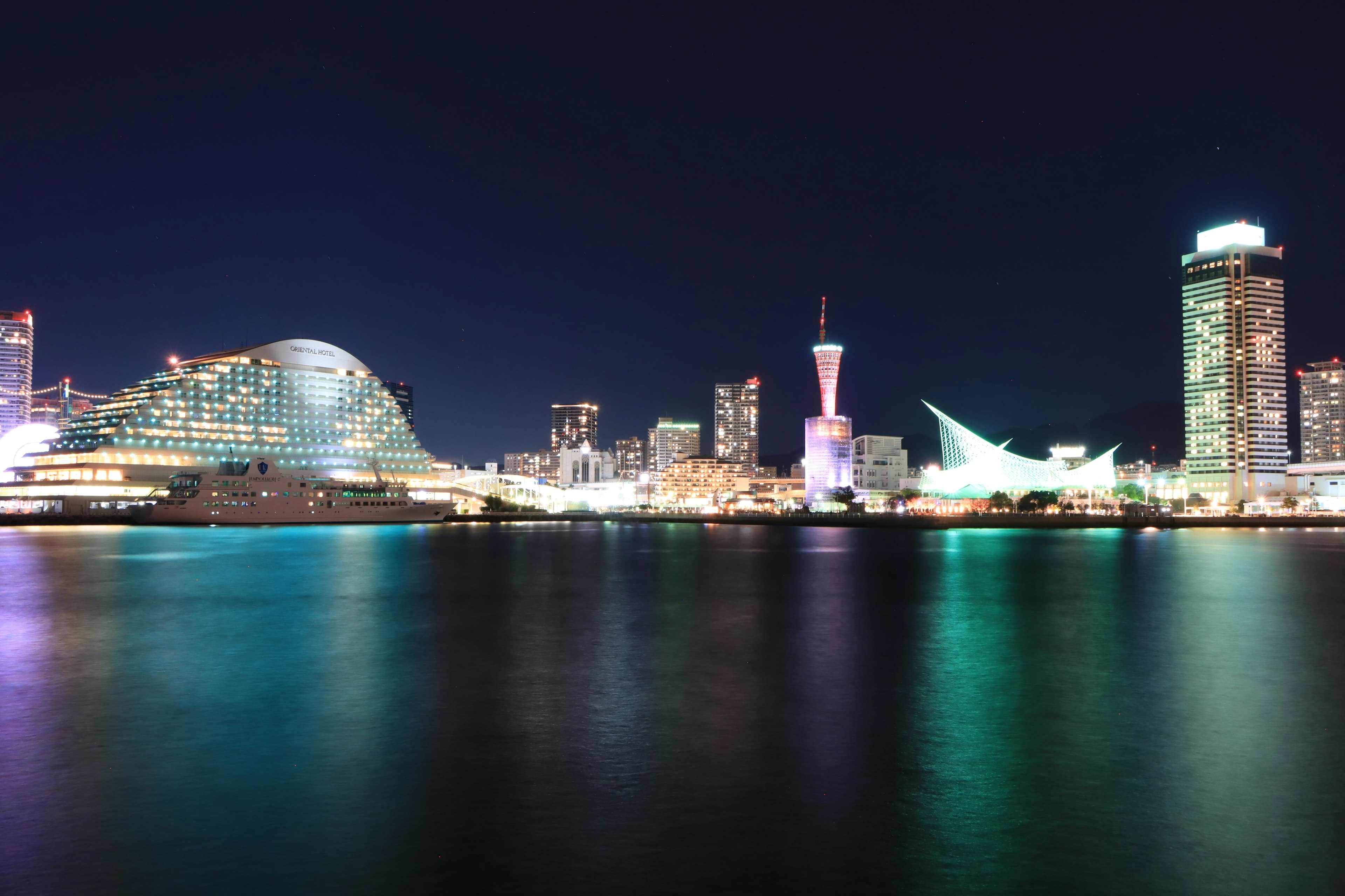 Vue nocturne de Yokohama bord de mer avec des reflets sur l'eau silhouette moderne