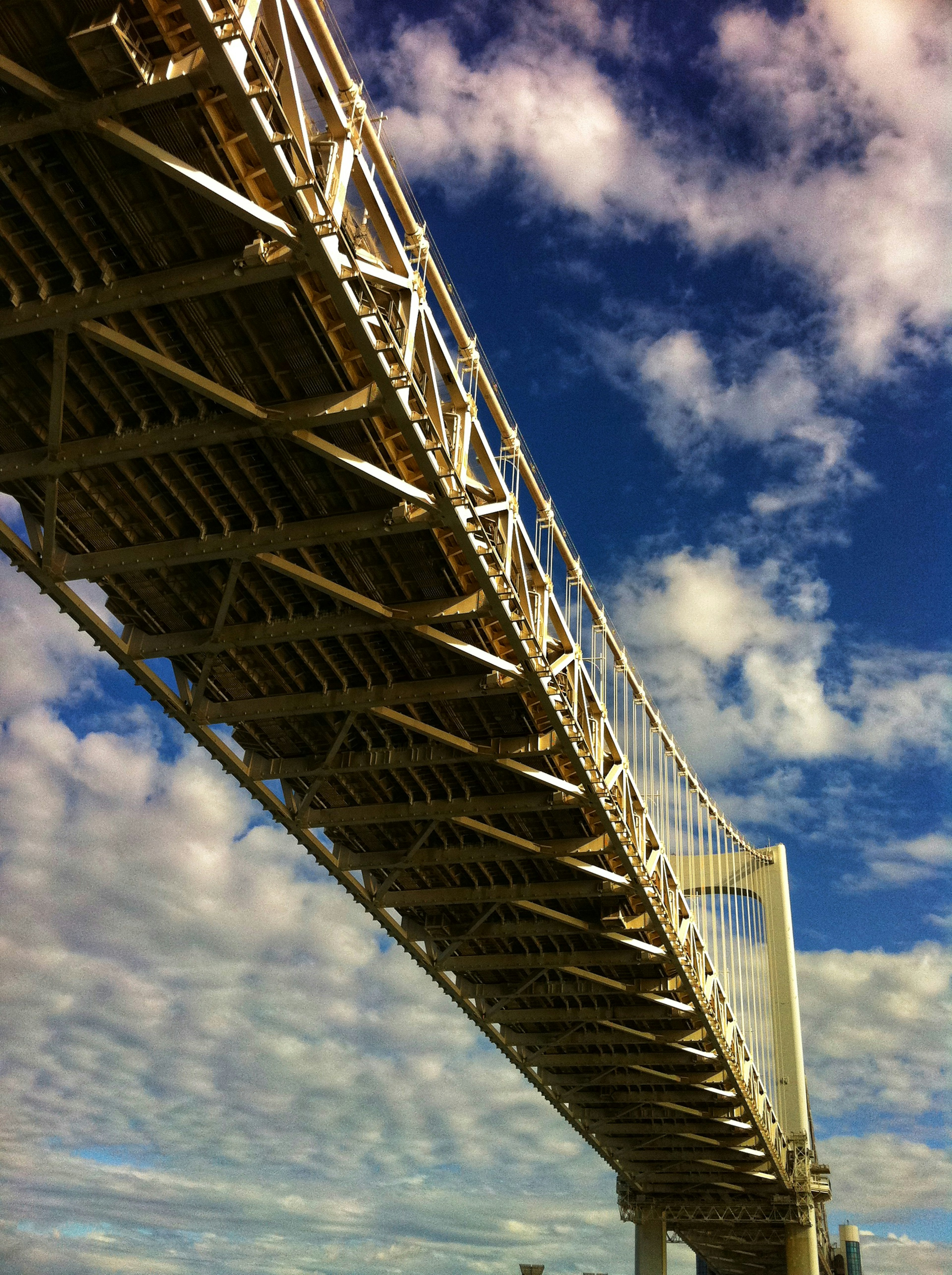 View of a white bridge against a blue sky with scattered clouds