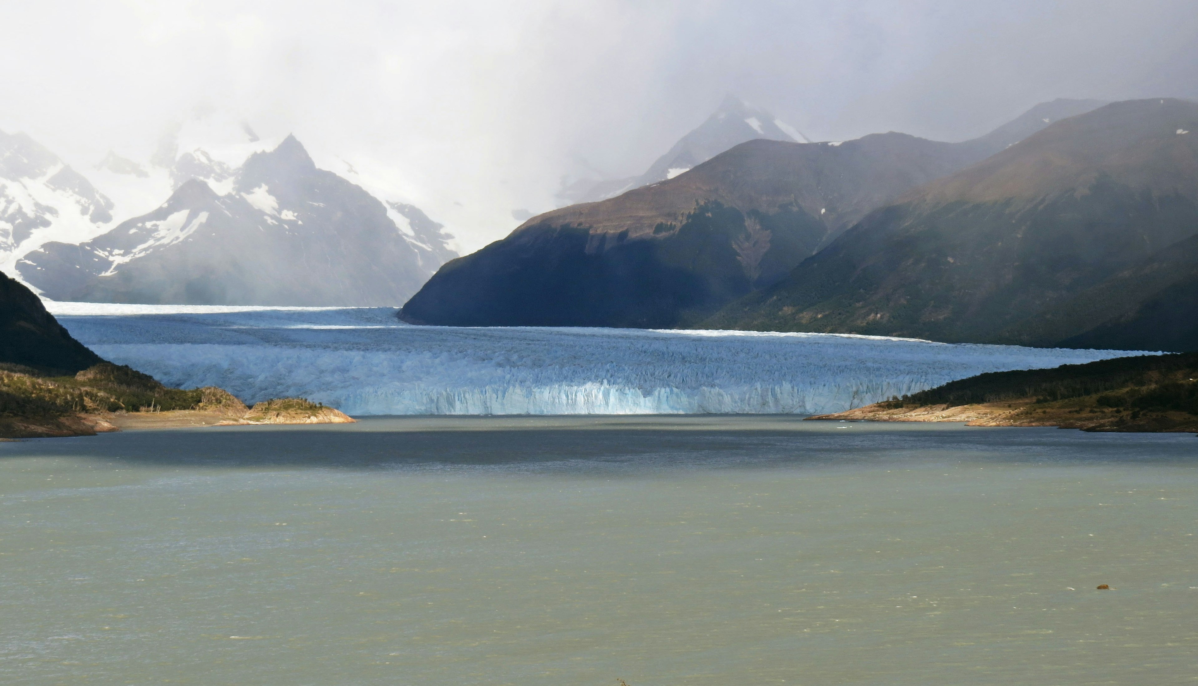 Malersicher Blick auf einen See umgeben von Bergen und einem Gletscher