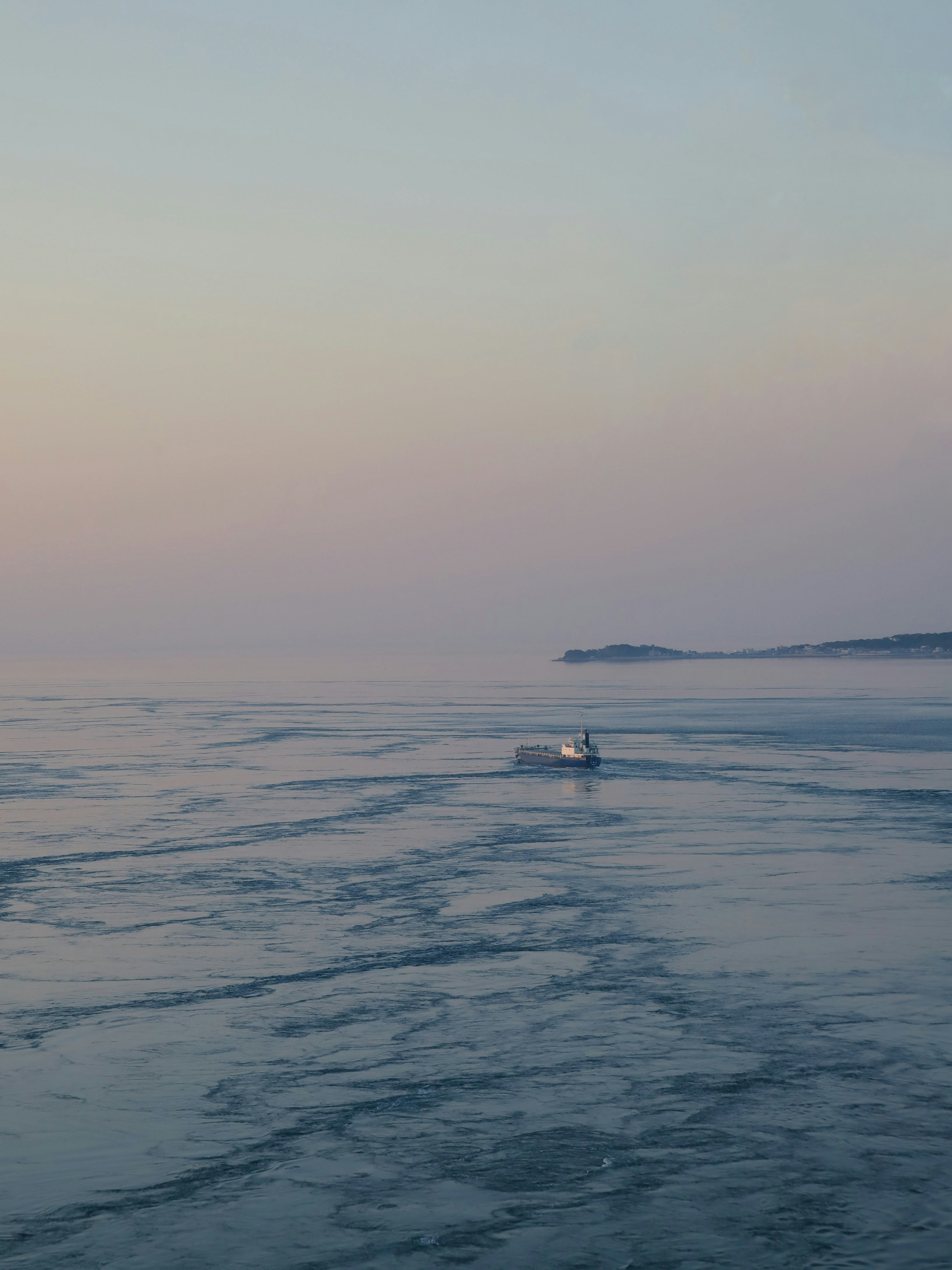 Sebuah perahu kecil mengapung di laut tenang saat senja