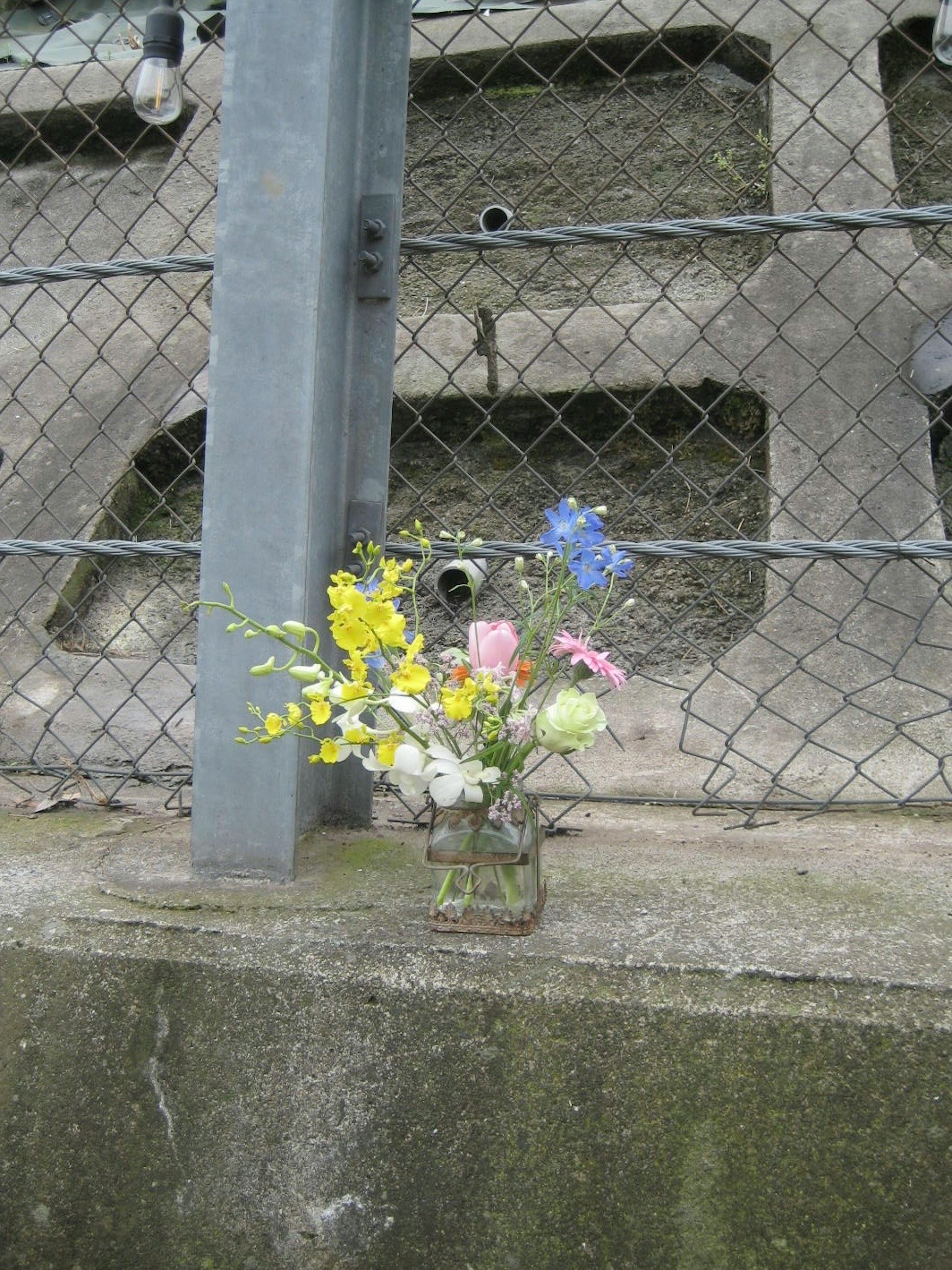 花束がフェンスの近くに置かれている風景