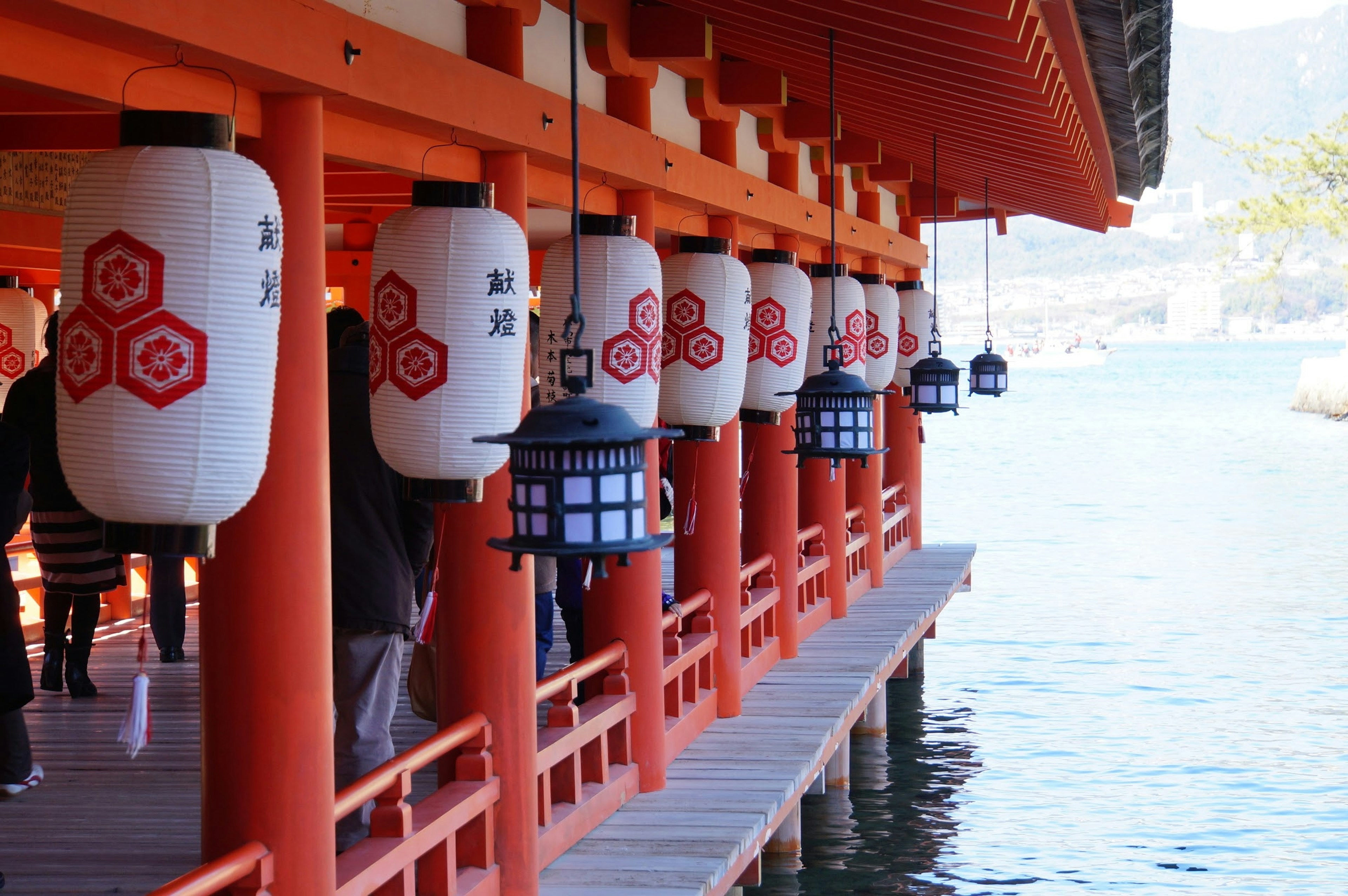 Pier of a shrine with red columns and hanging lanterns