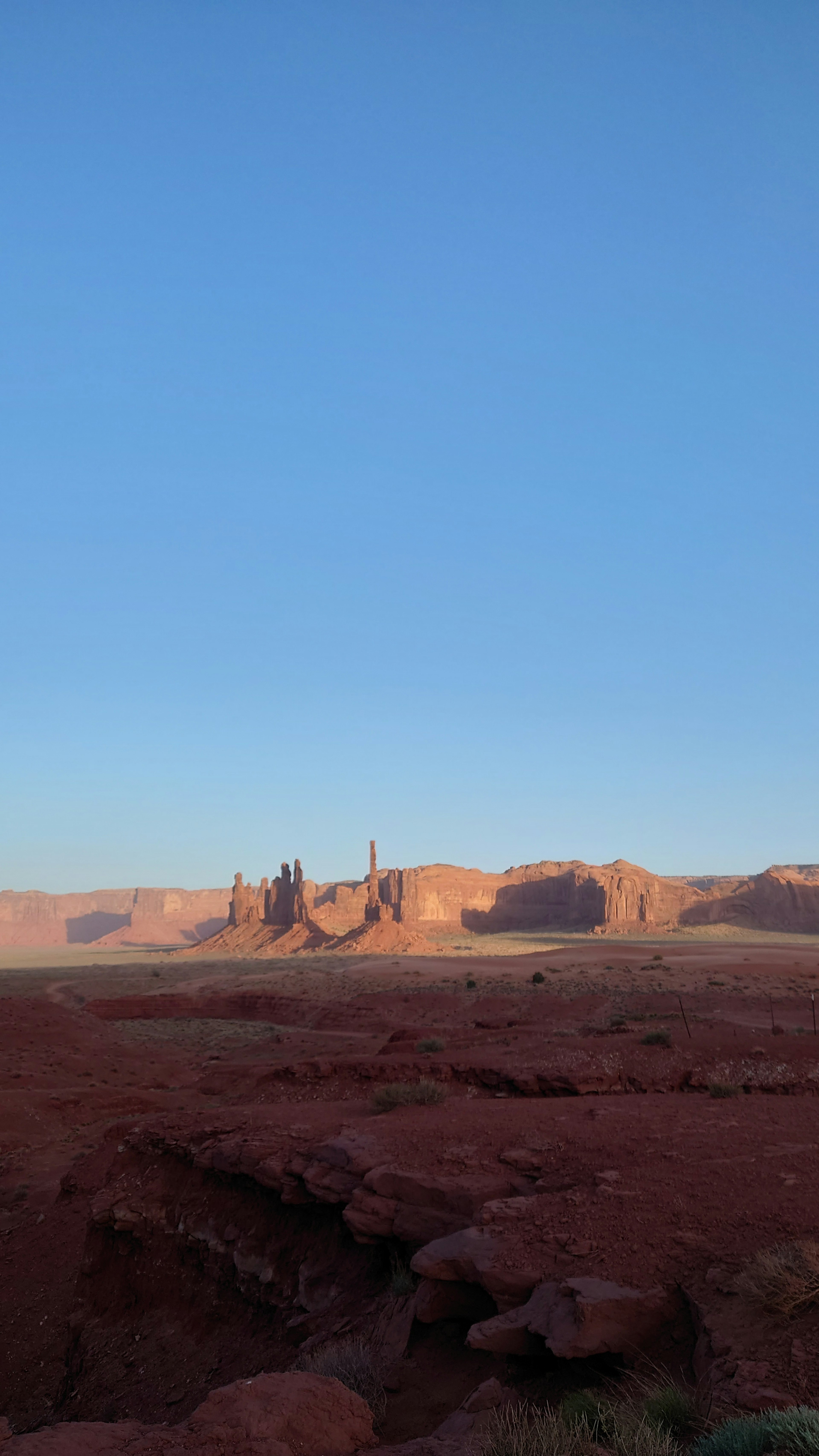 Paisaje con tierra roja y cielo azul con formaciones rocosas imponentes