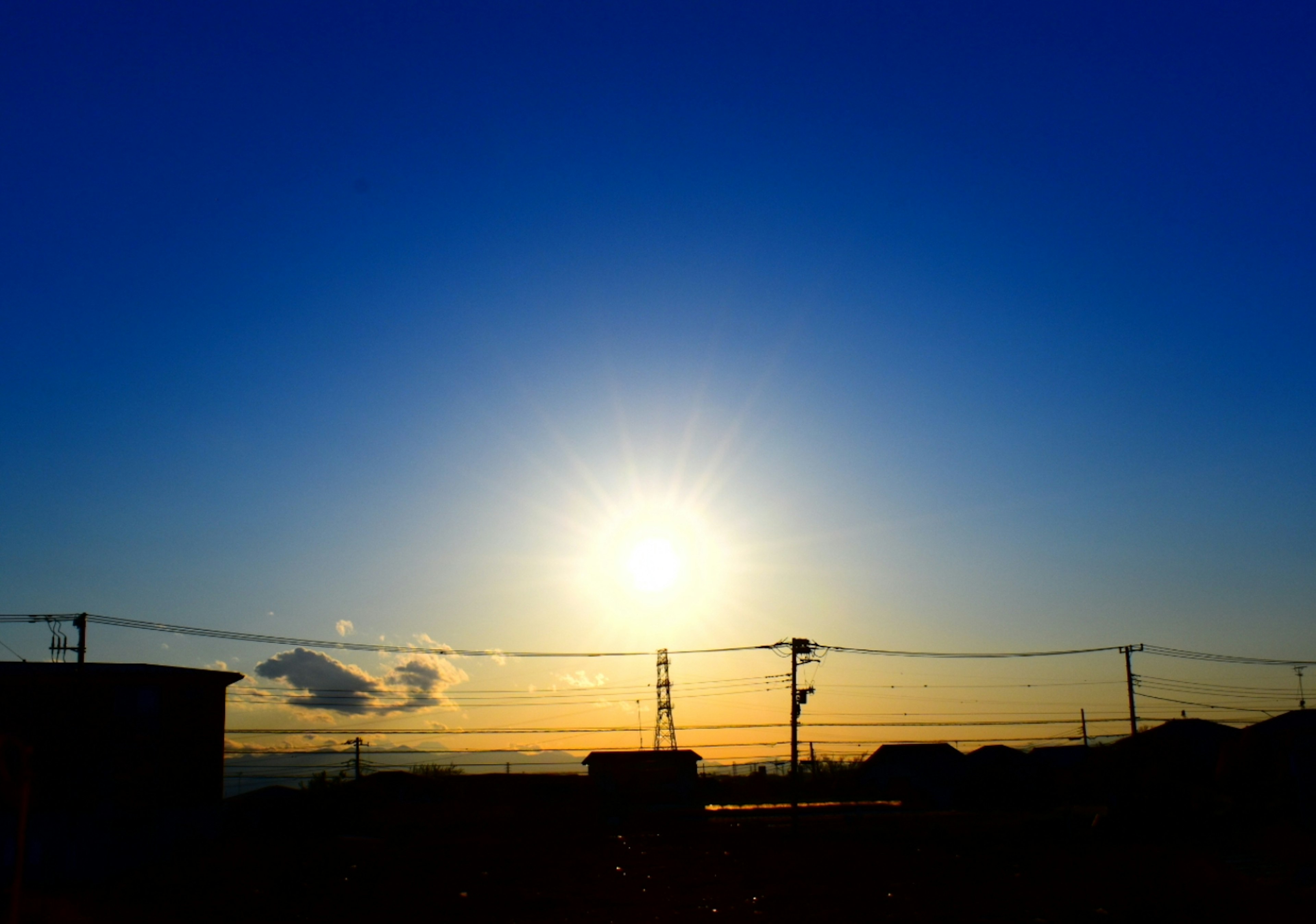 Sunset with silhouetted buildings against a blue sky