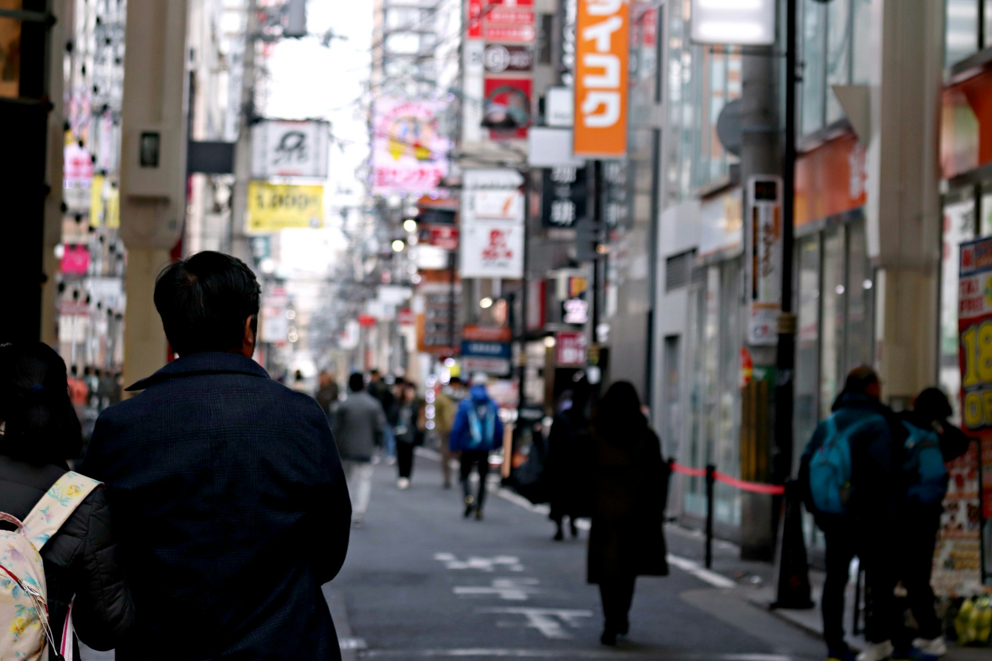 Bustling street scene with pedestrians and vibrant shop signs