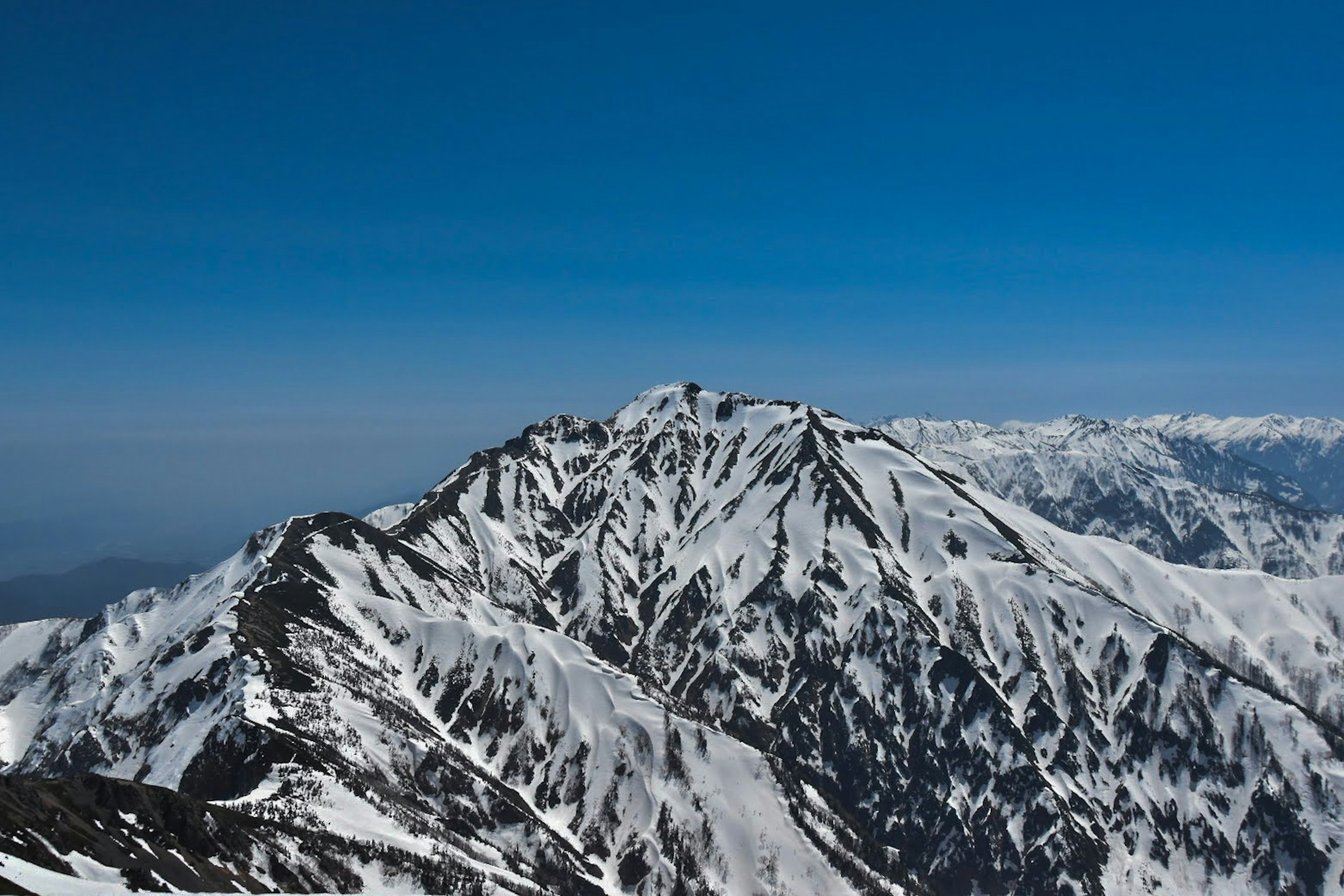 雪に覆われた山の風景 青い空の下で