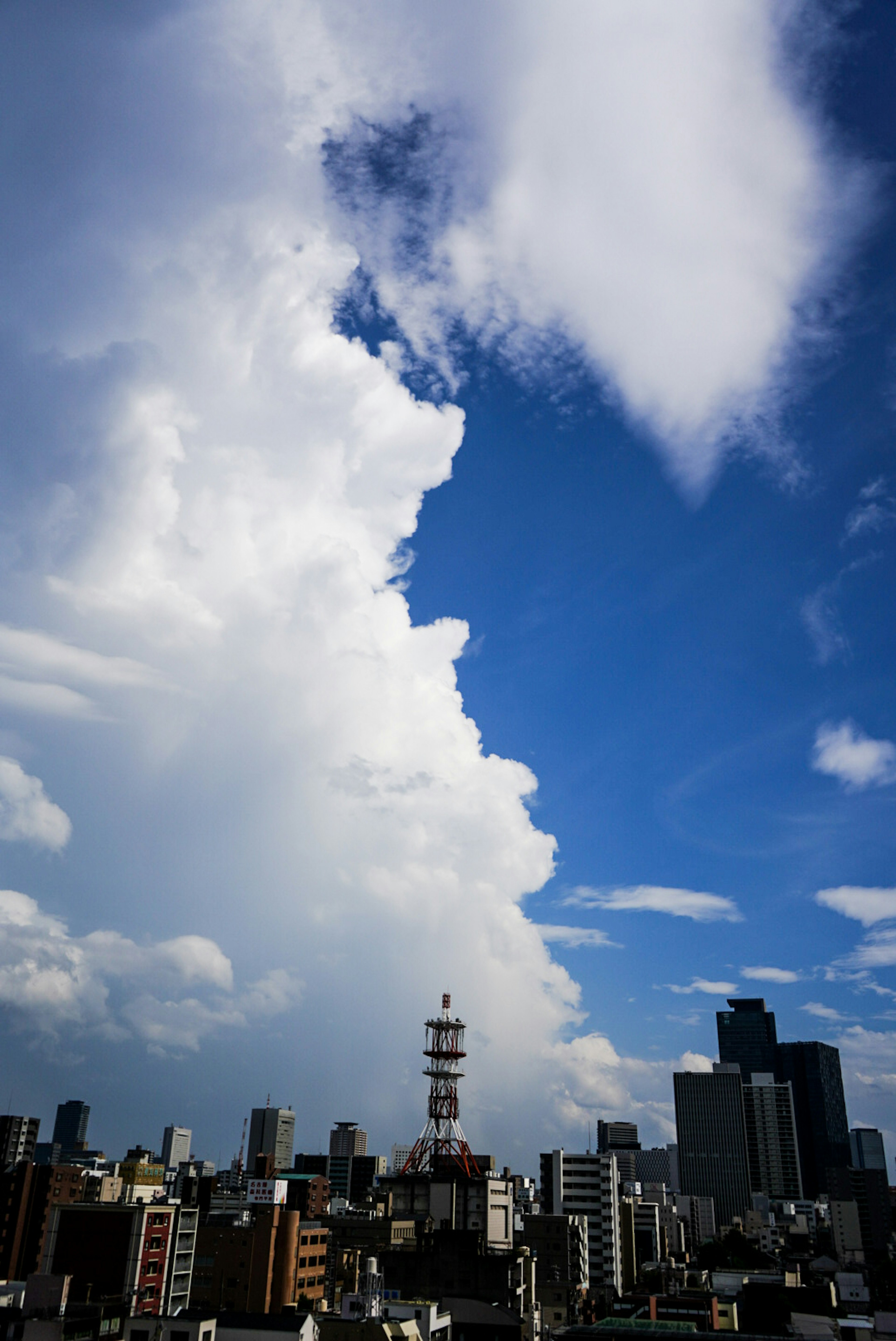 City skyline with dramatic clouds and blue sky