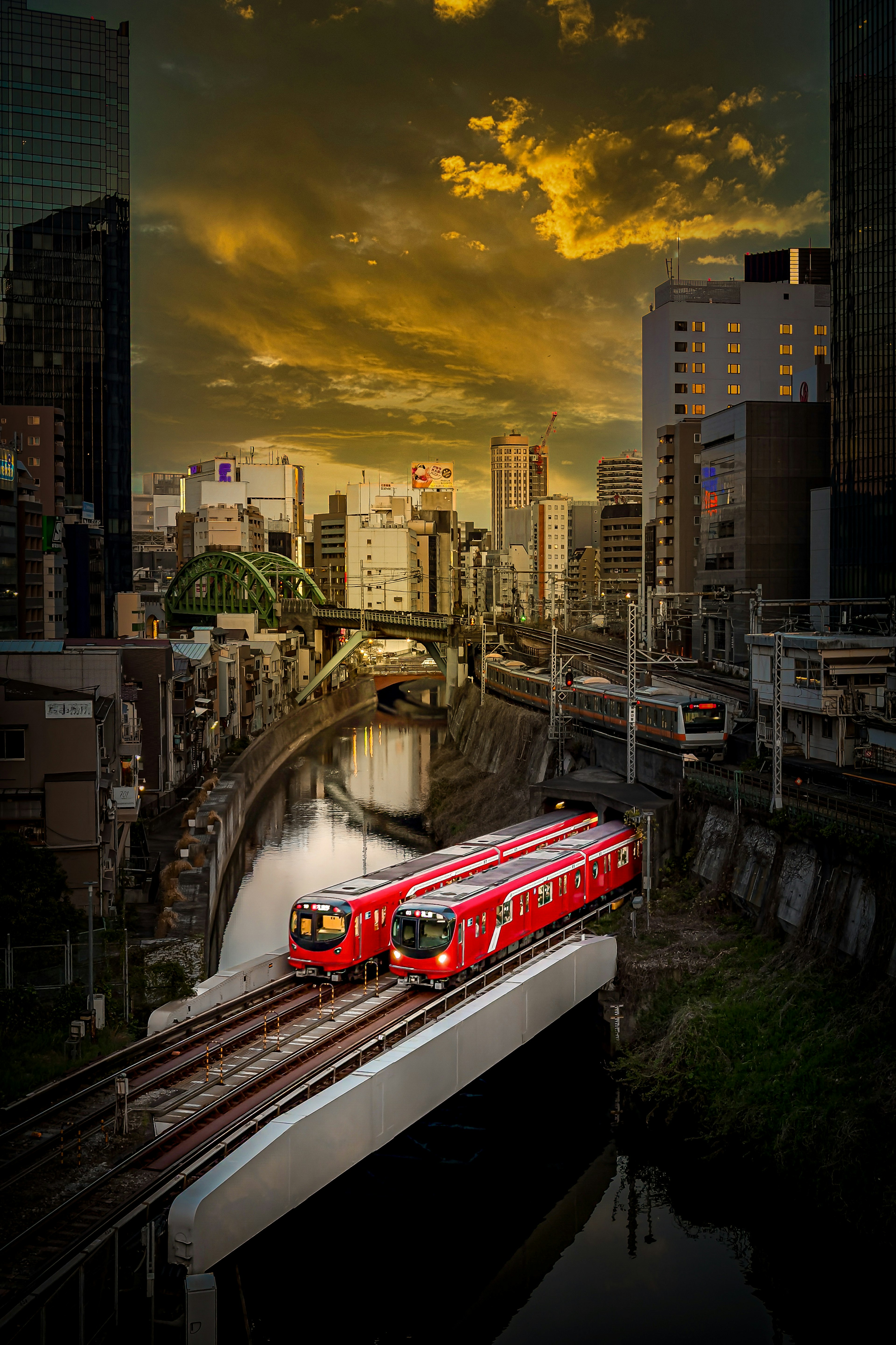 Trenes rojos corriendo en un paisaje urbano iluminado por el atardecer