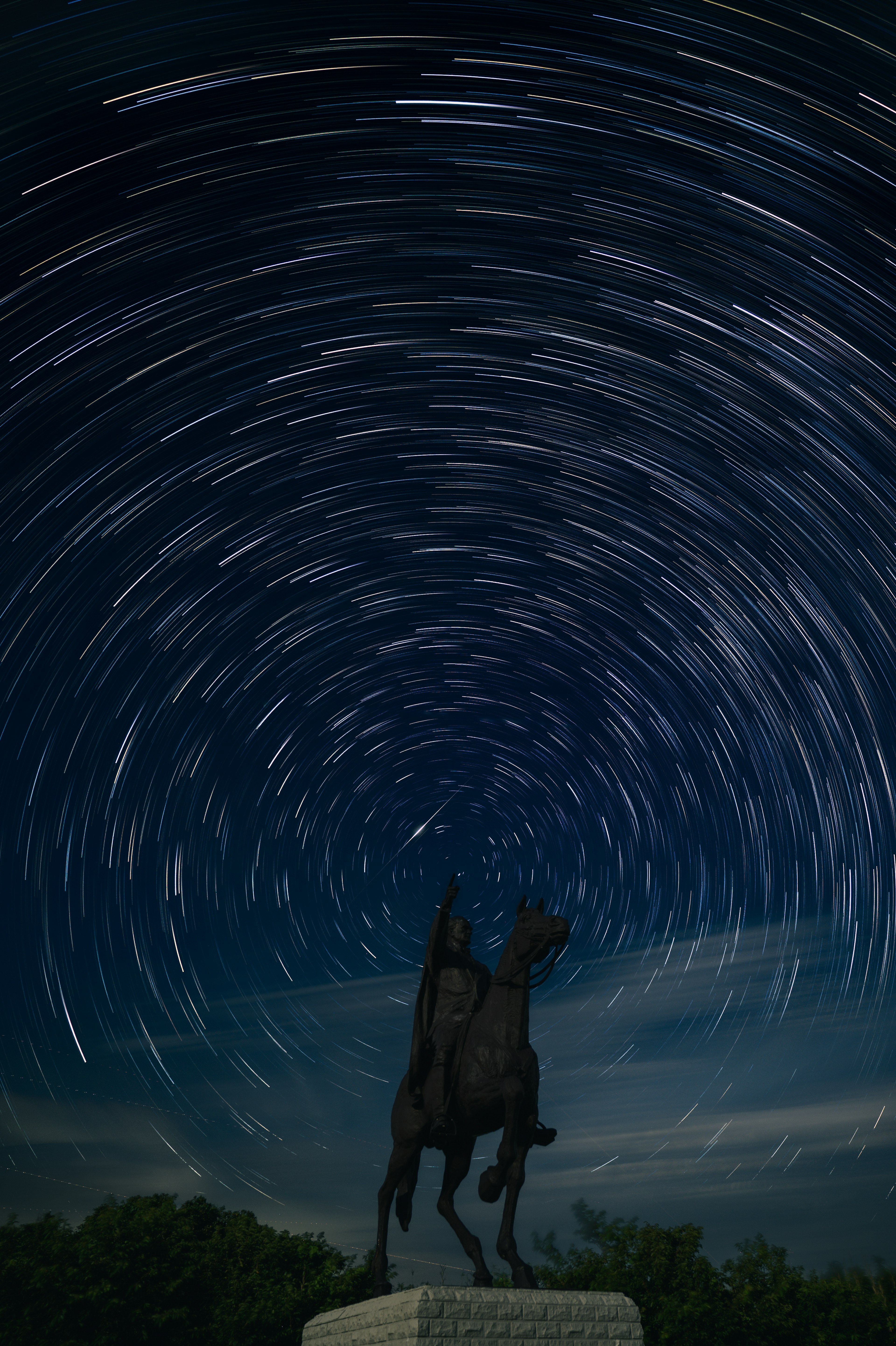 星の軌跡の中に立つ騎士像の風景