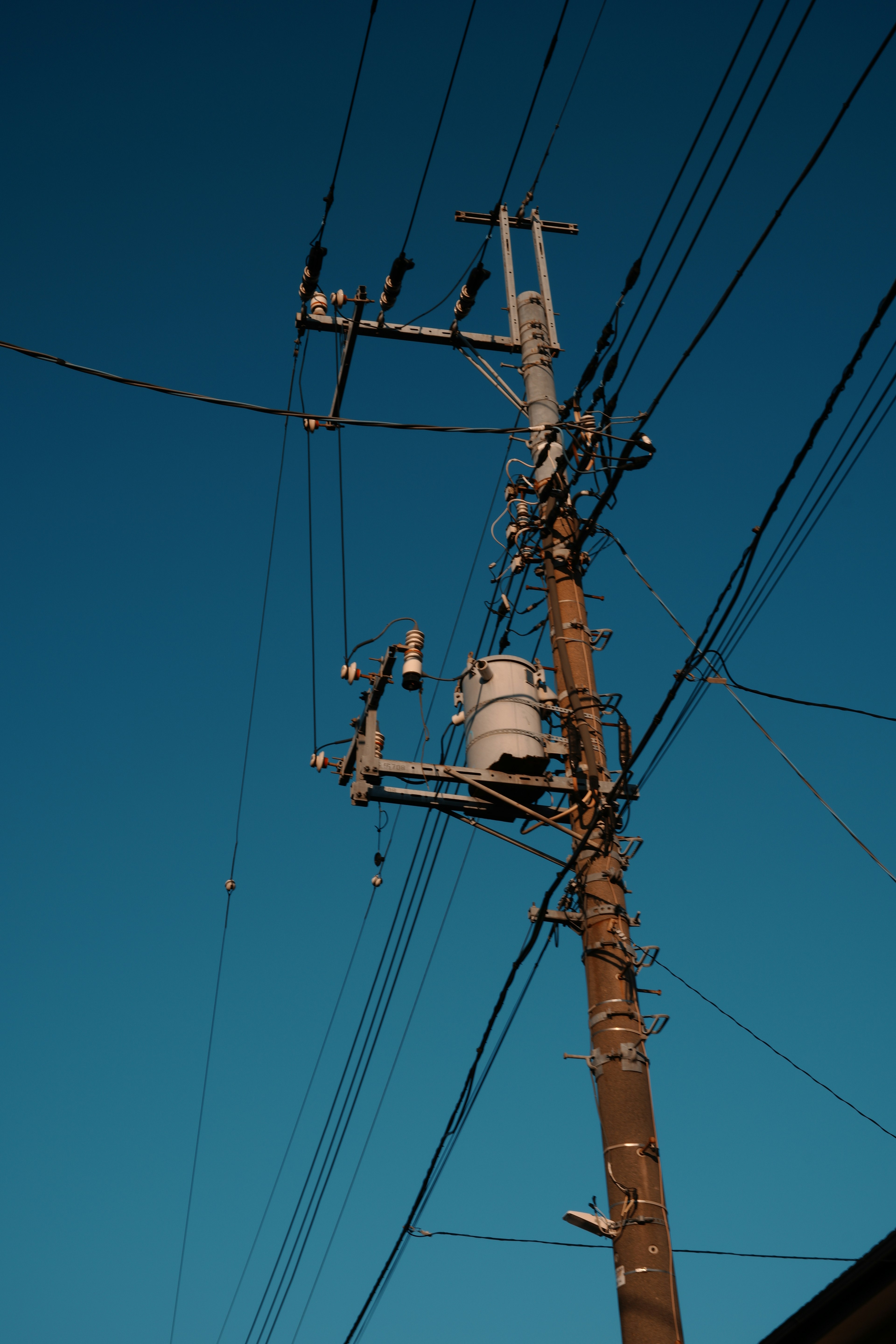 青空の下に立つ電柱と電線の詳細