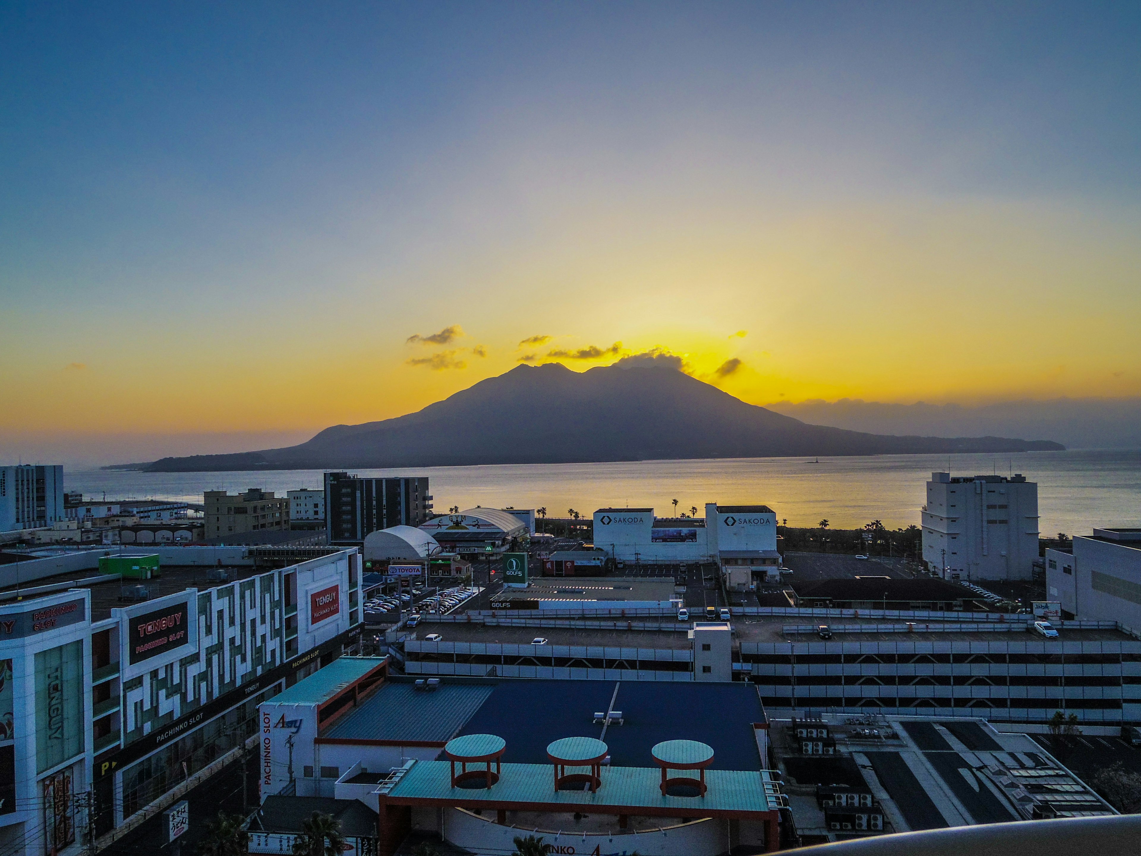 Scenic view of a mountain at sunset with urban buildings in the foreground