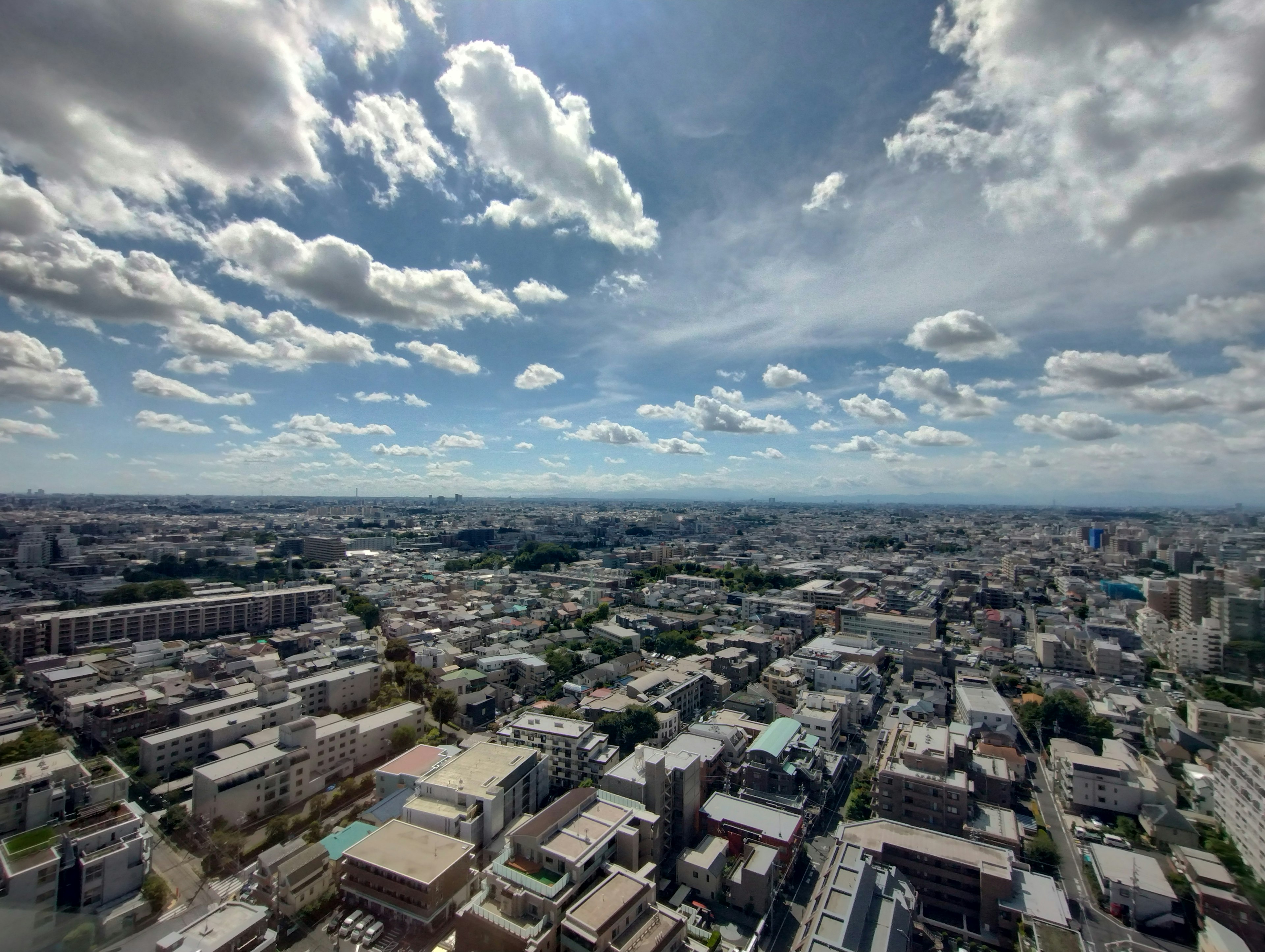 Expansive cityscape with blue sky and scattered clouds