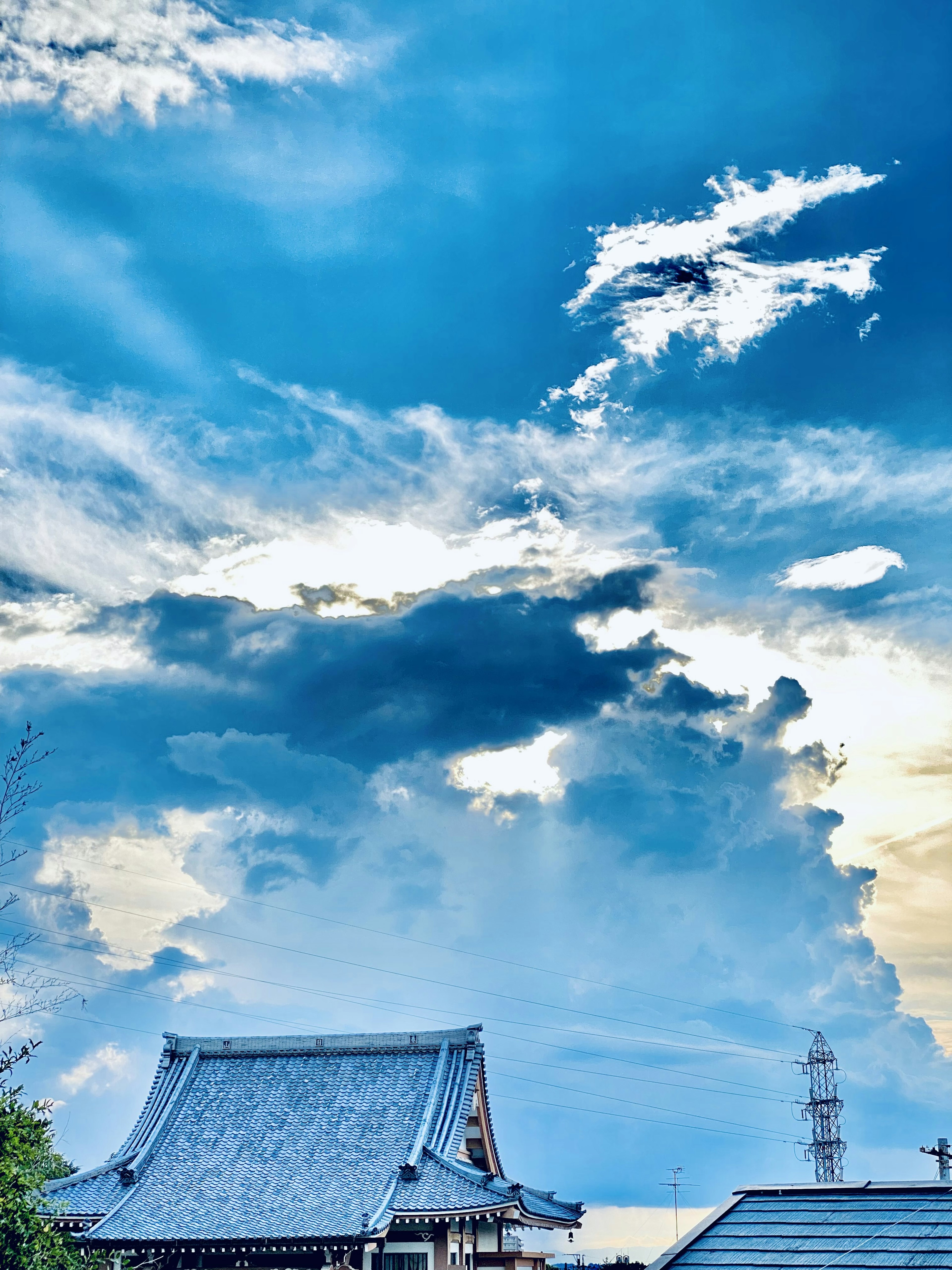 青空と雲が広がる風景と伝統的な屋根の建物