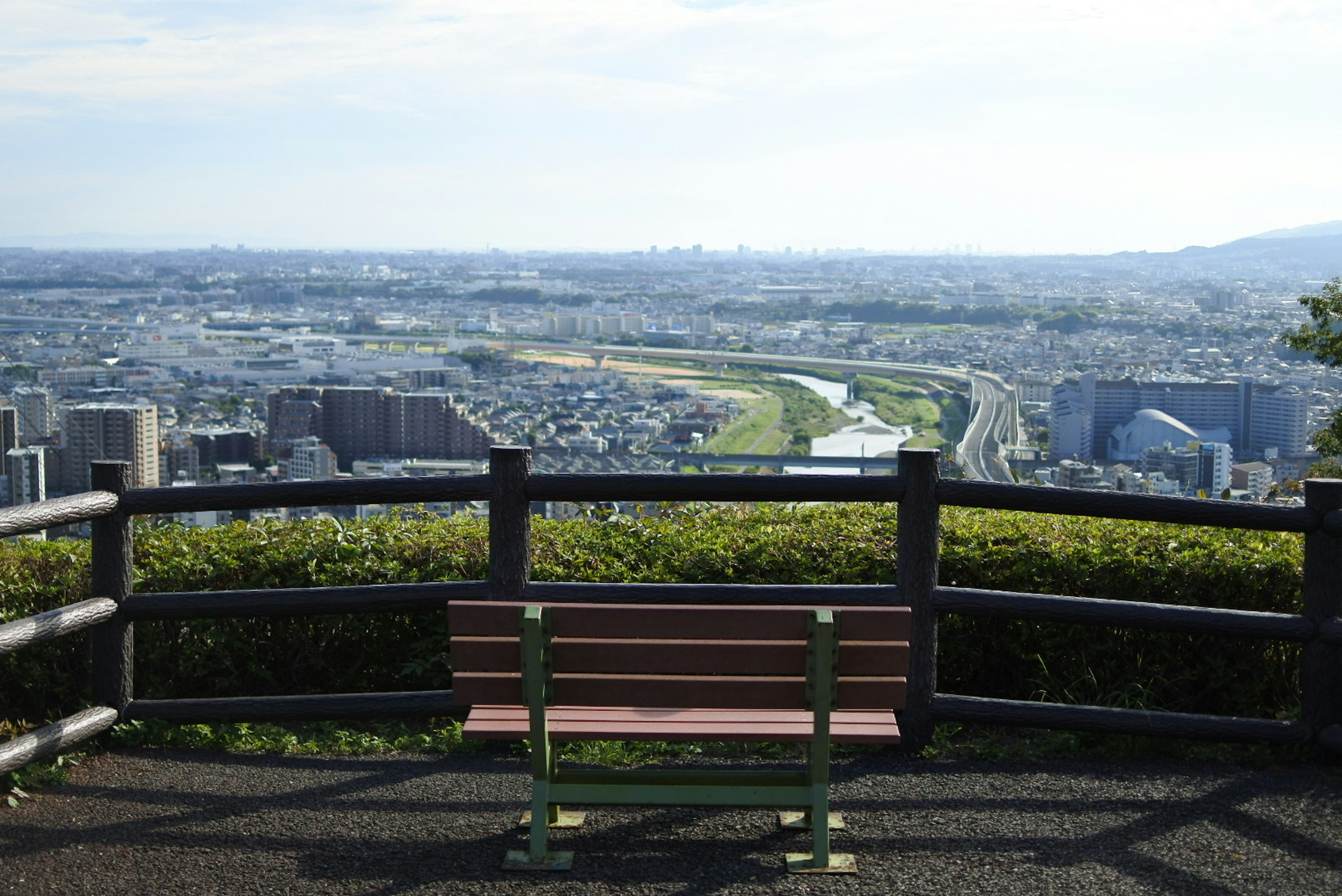 緑の囲いとベンチがある展望台からの景色