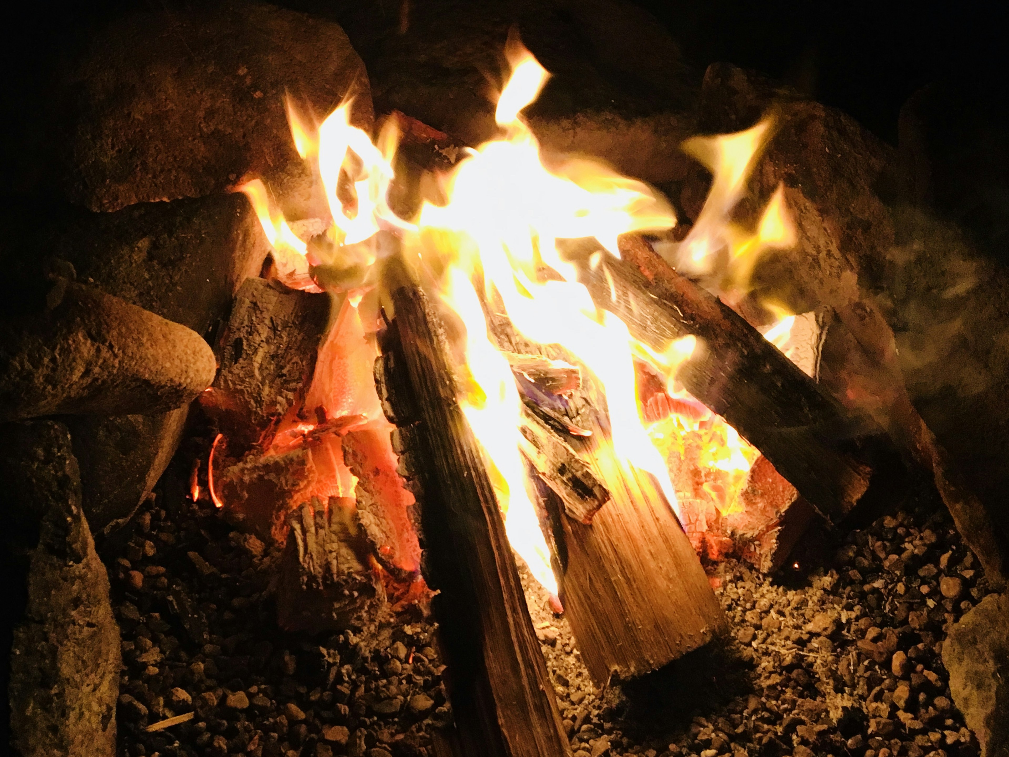 Flickering flames of a campfire at night