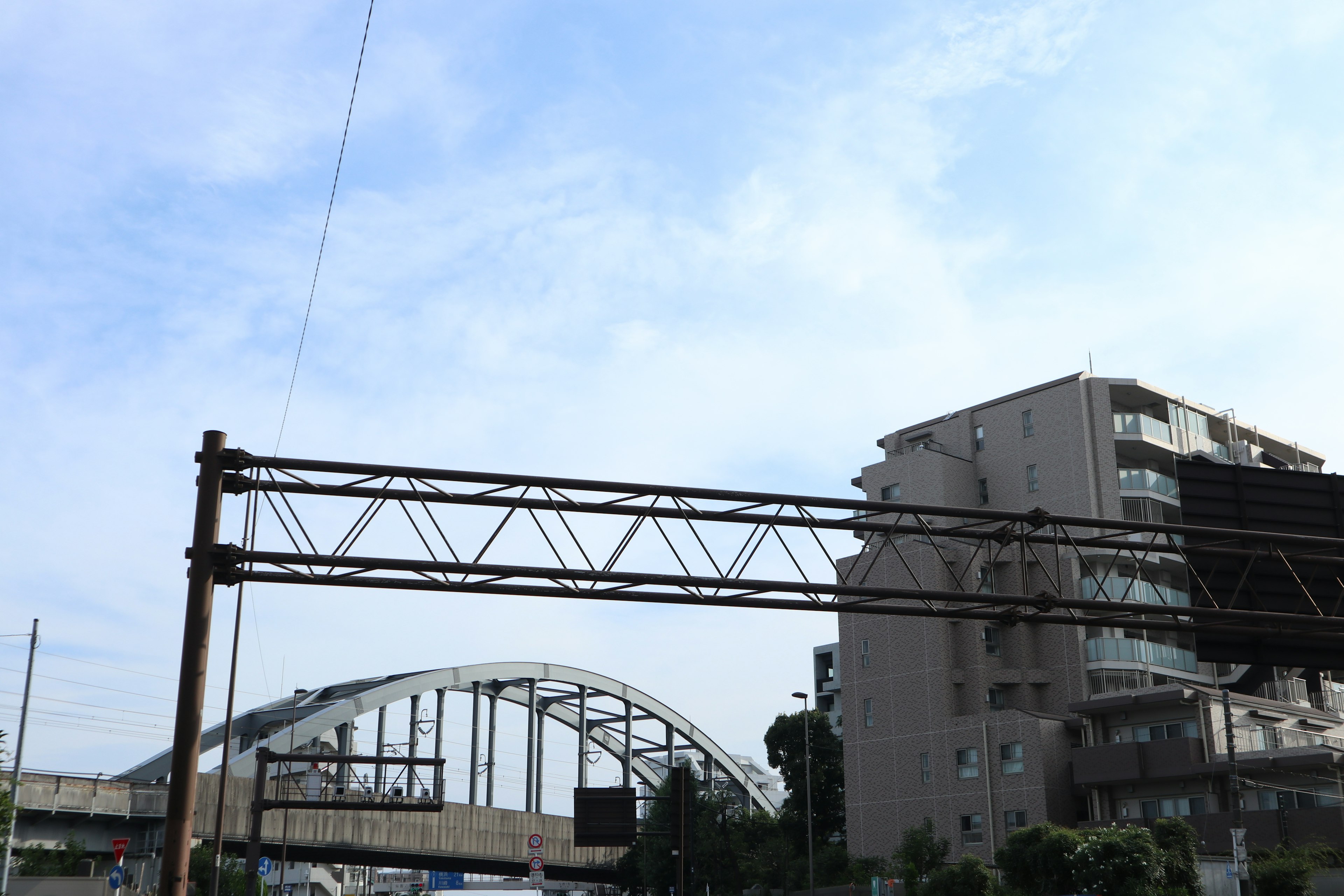 ทัศนียภาพของสะพานรถไฟและอาคารสูงใต้ท้องฟ้าสีฟ้า