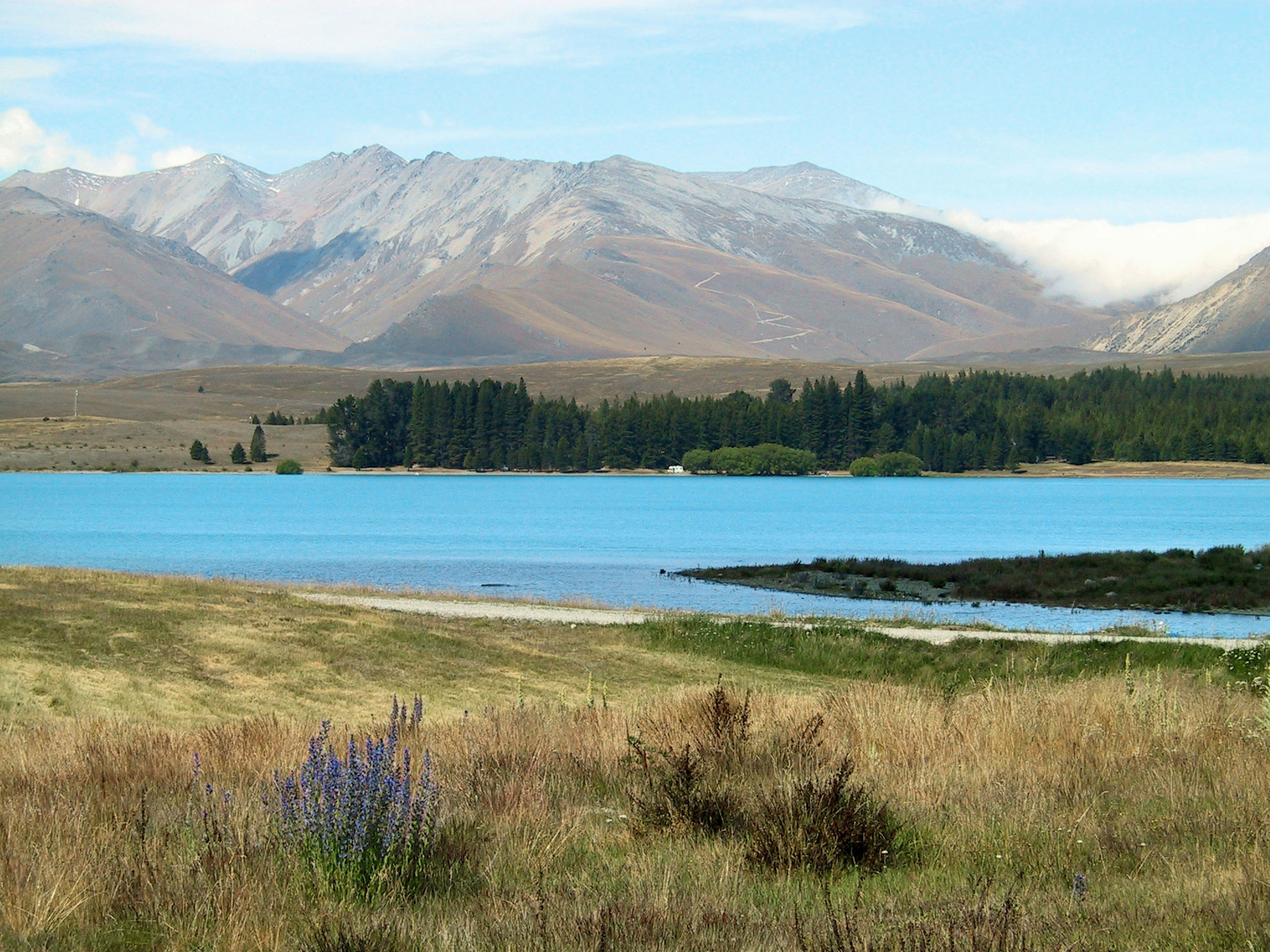 Vue panoramique d'un lac turquoise entouré de montagnes