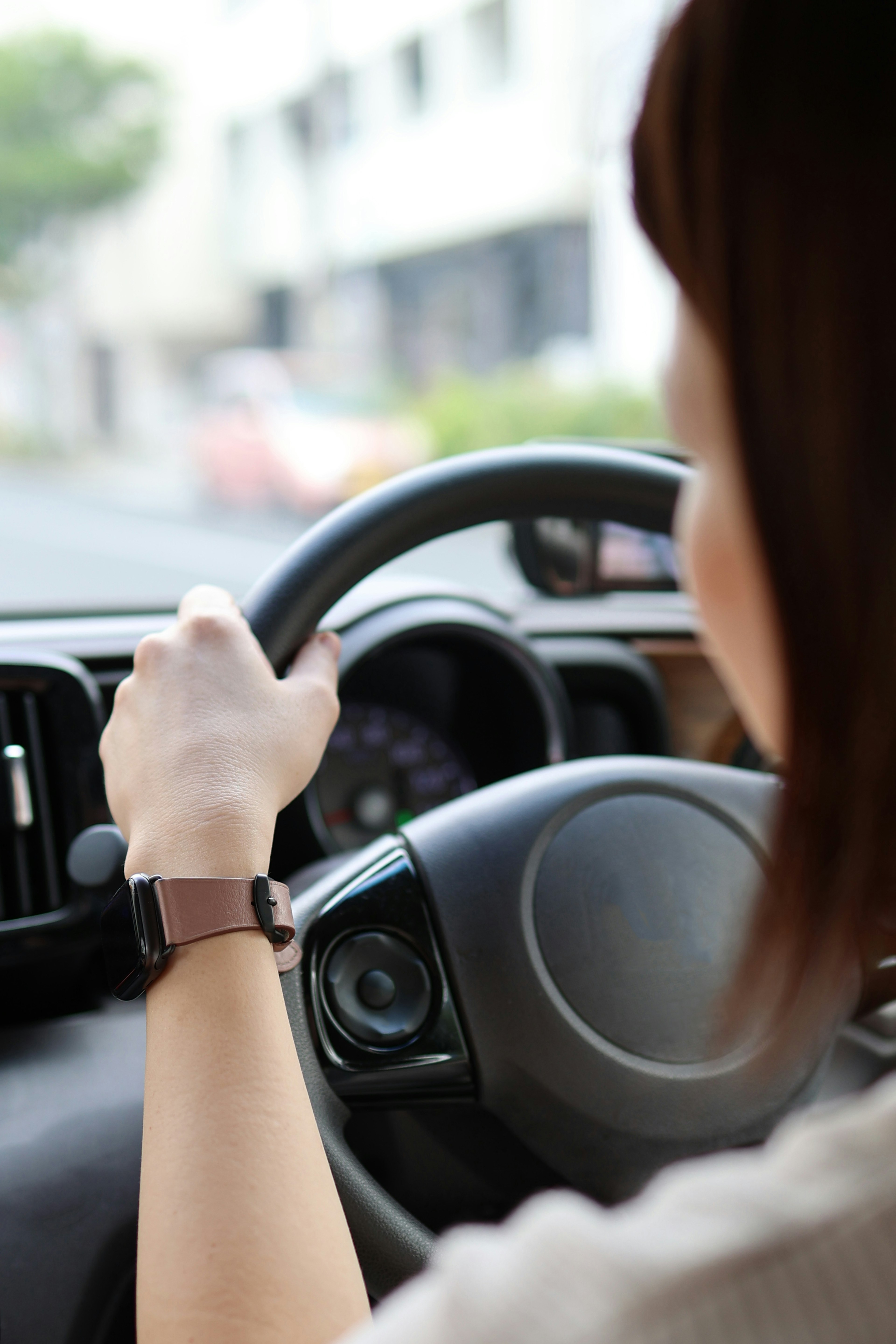 A woman driving a car holding the steering wheel