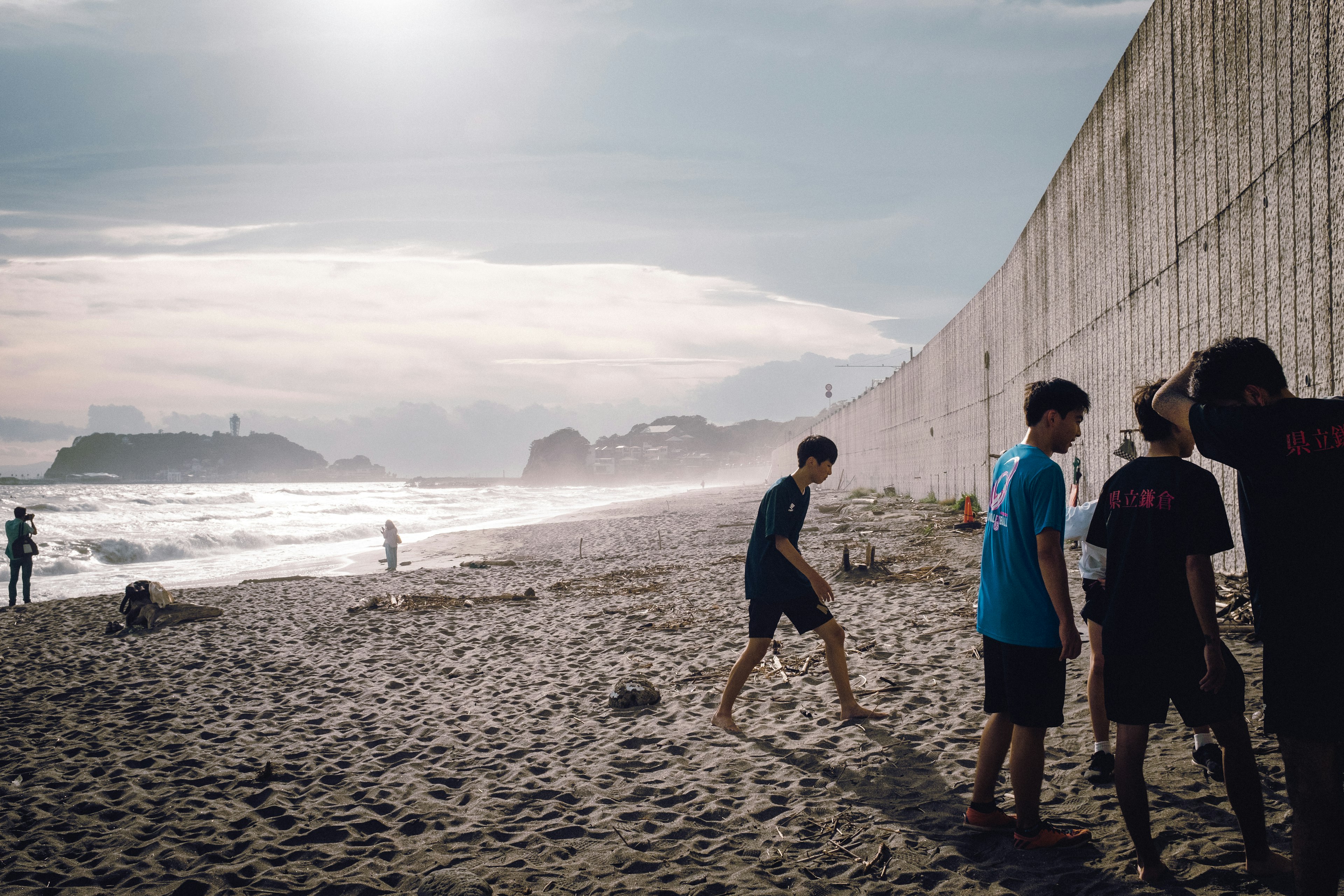 Children playing on the beach with a wall in the background