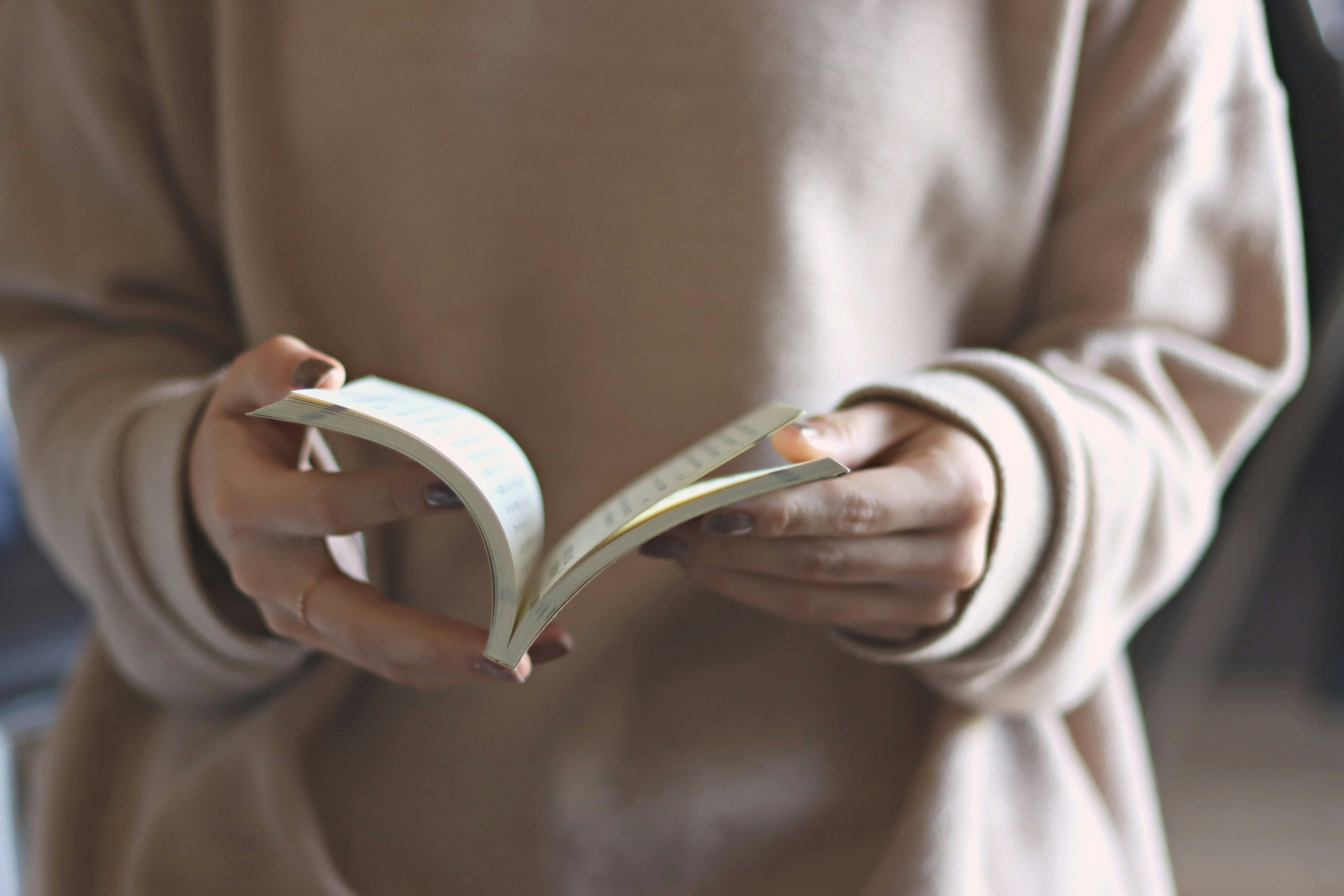 Una mujer sosteniendo un libro con páginas abiertas