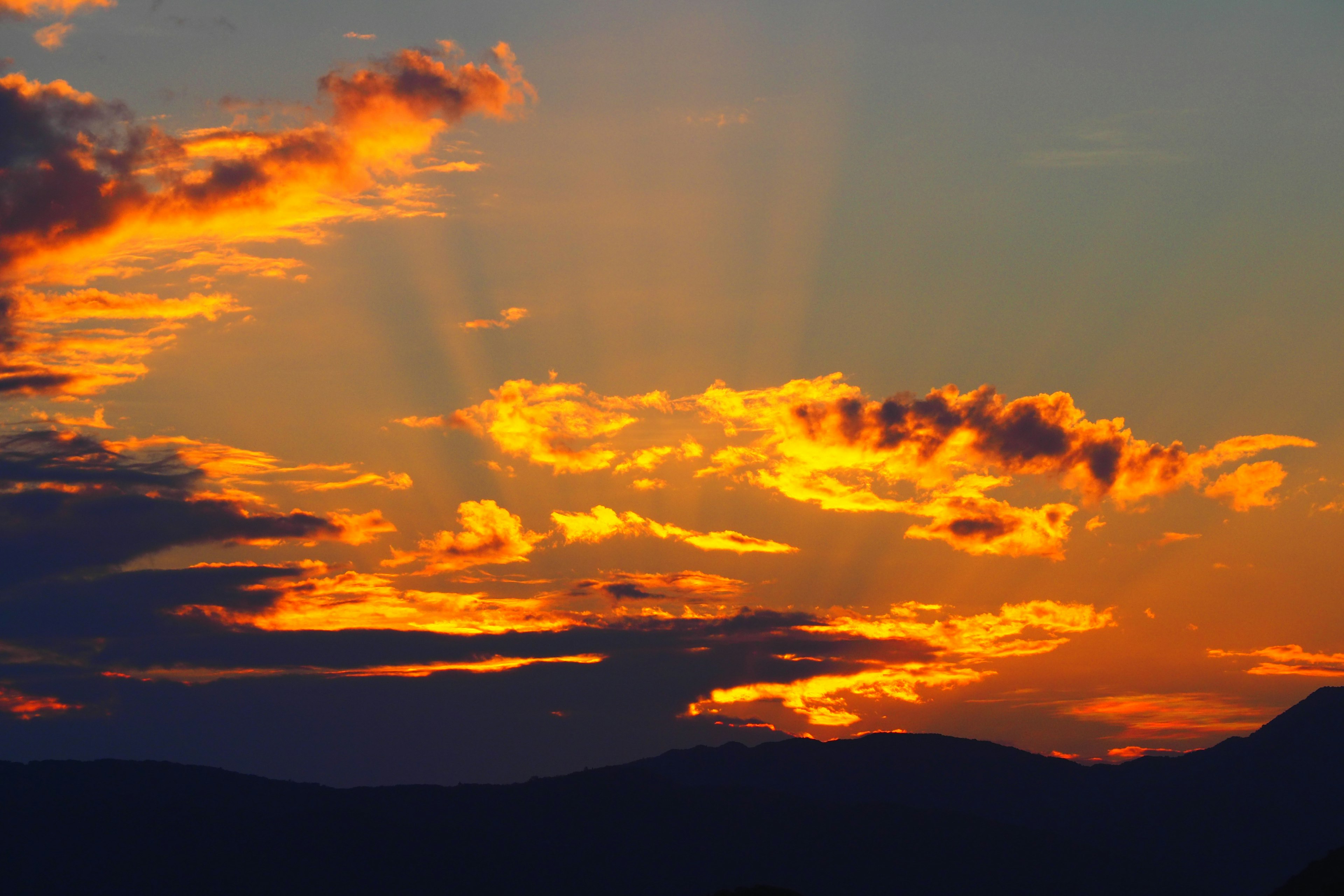 Cielo vibrante de atardecer con nubes naranjas y amarillas