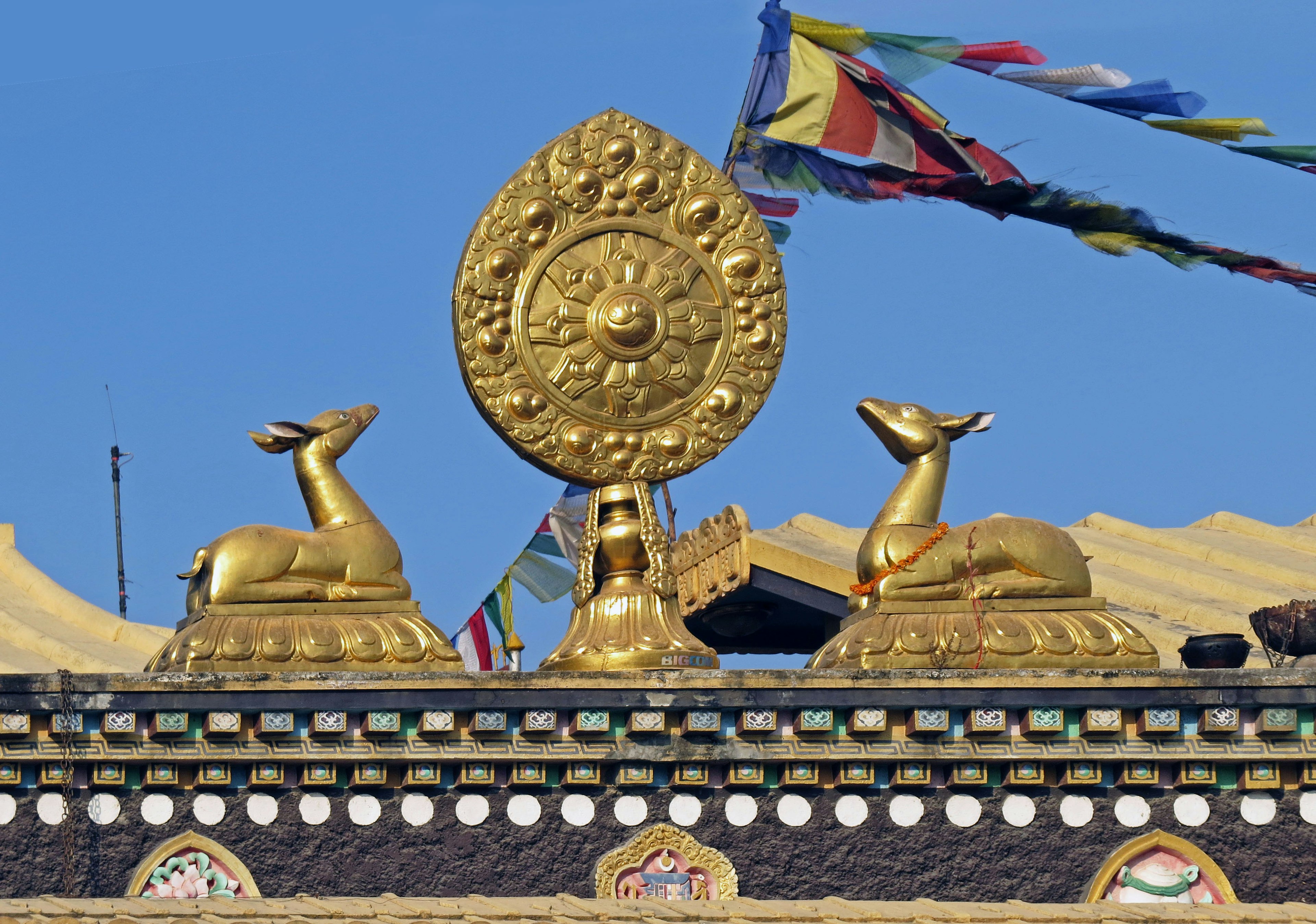 Golden symbols on a temple roof featuring two facing deer