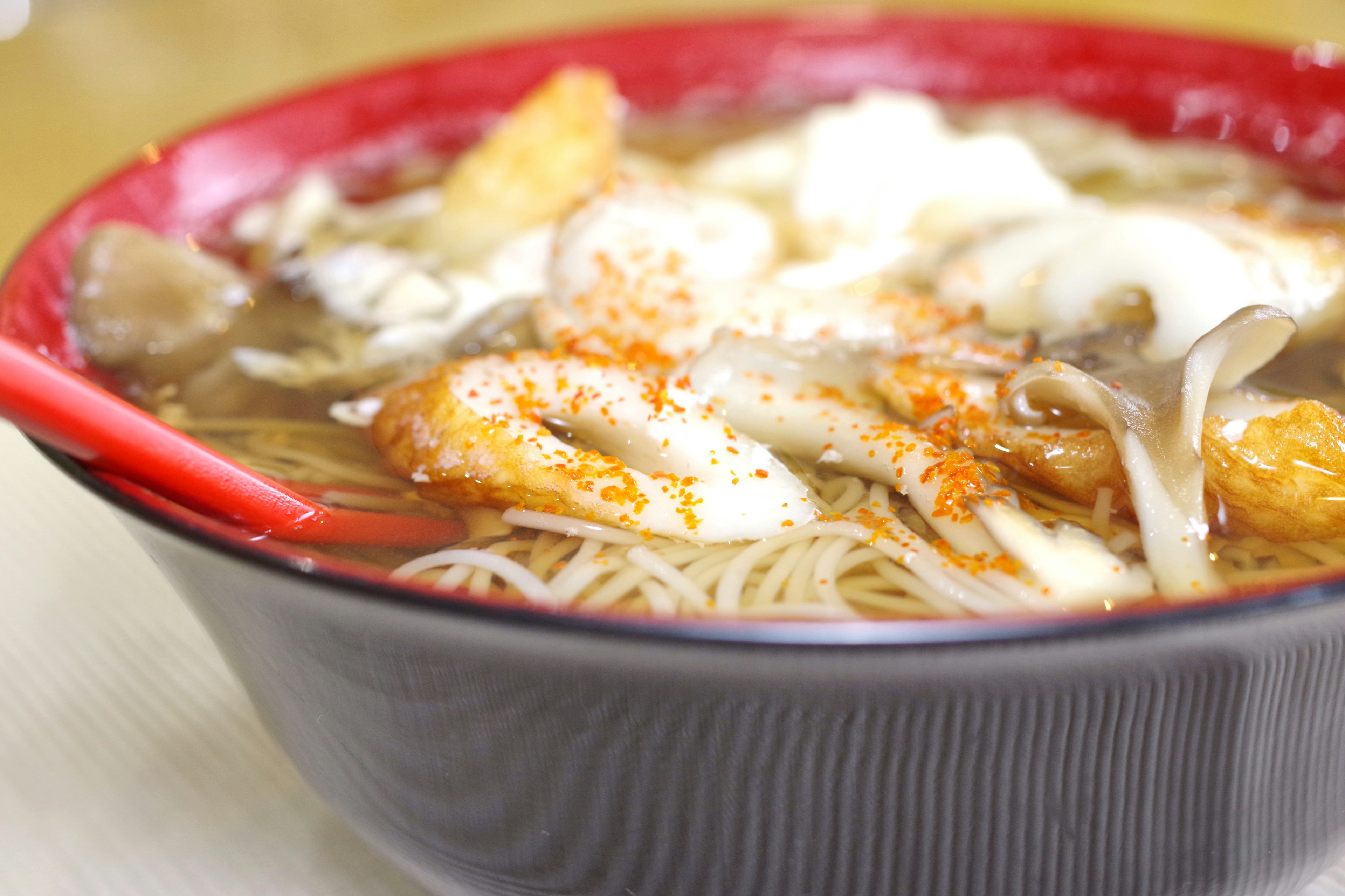 Tazón de ramen con varios ingredientes en un tazón rojo