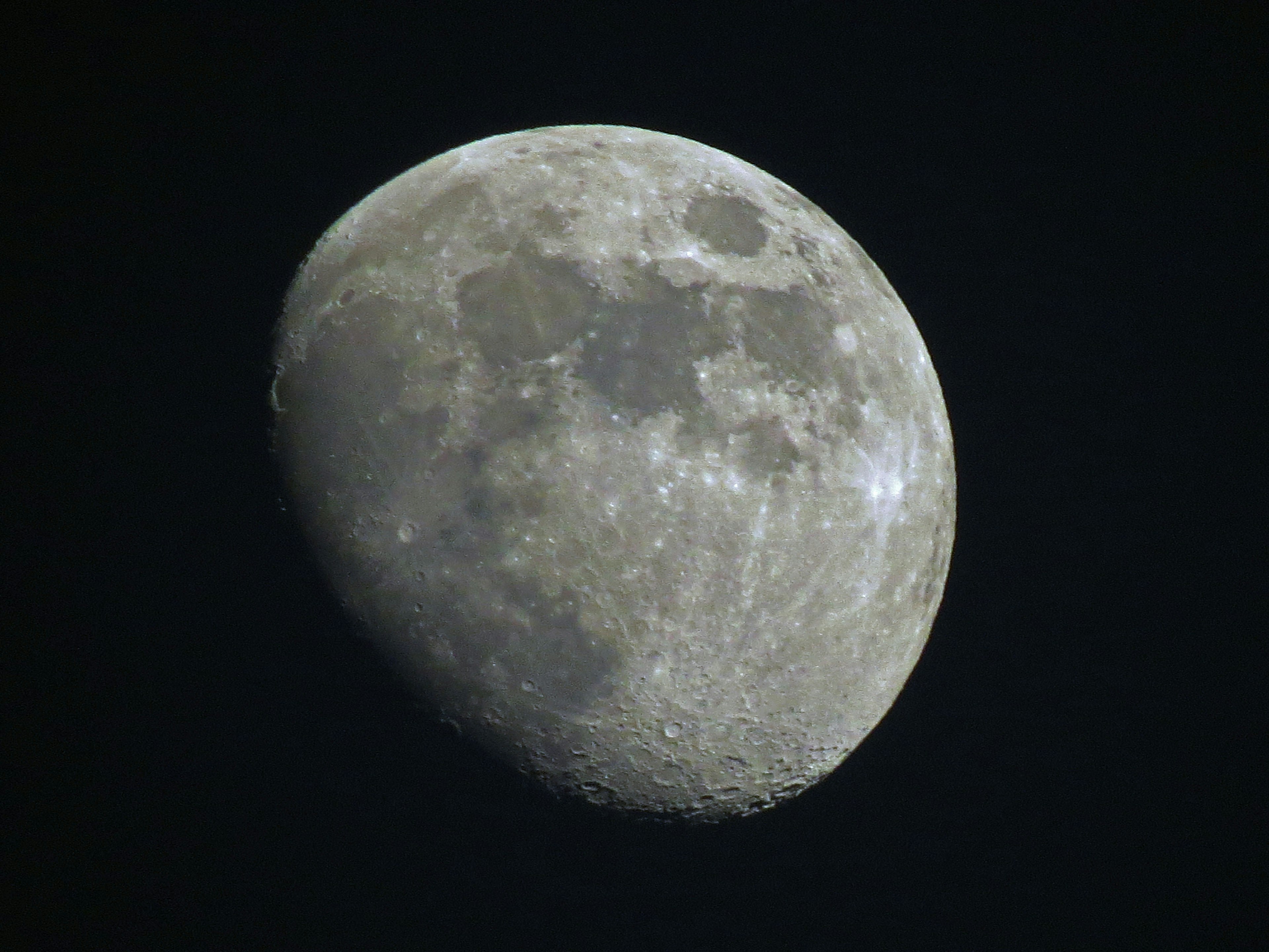 Close-up bulan di langit malam dengan kontras cahaya dan bayangan yang mencolok