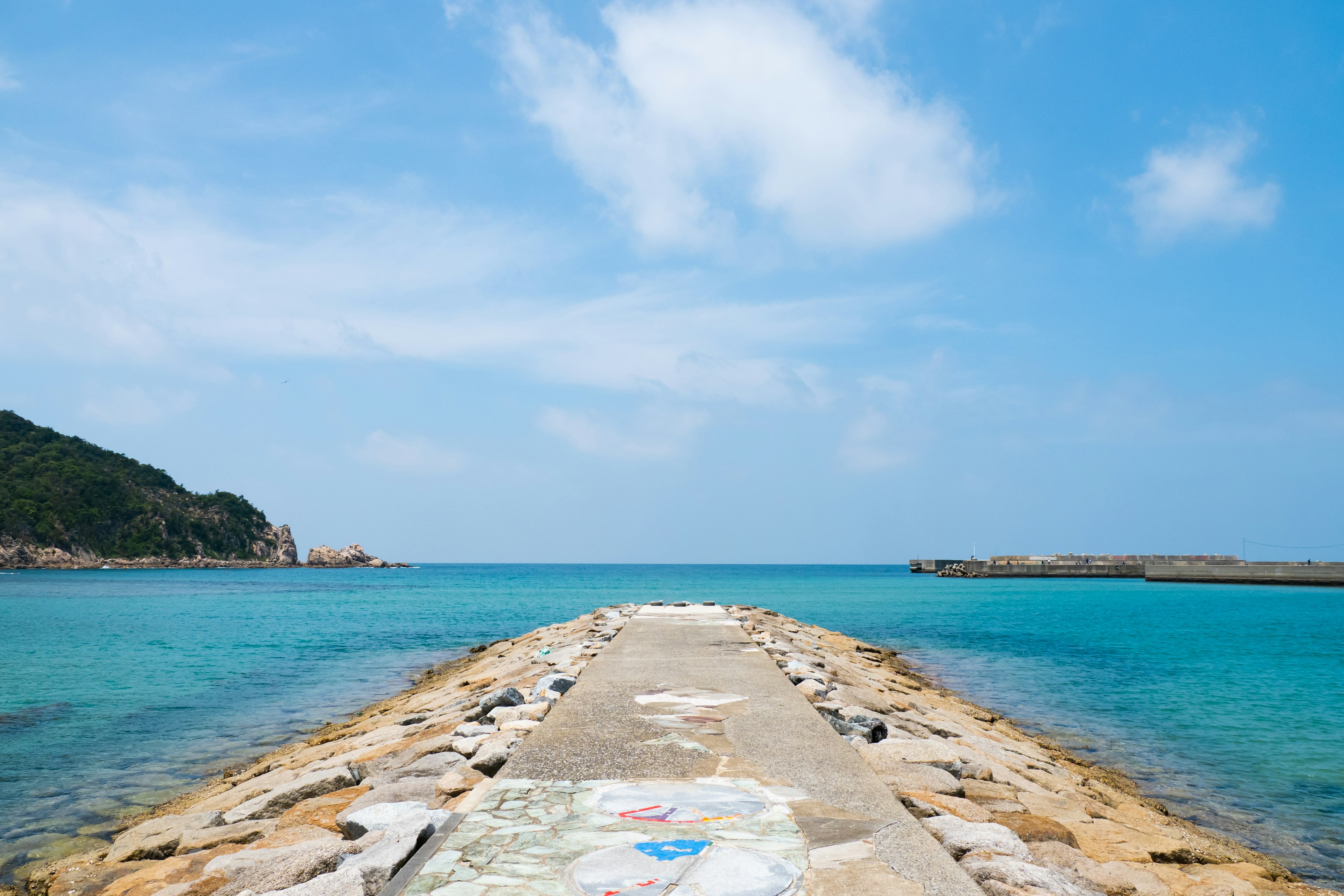 Bellissimo molo che si estende nel mare turchese sotto un cielo blu chiaro