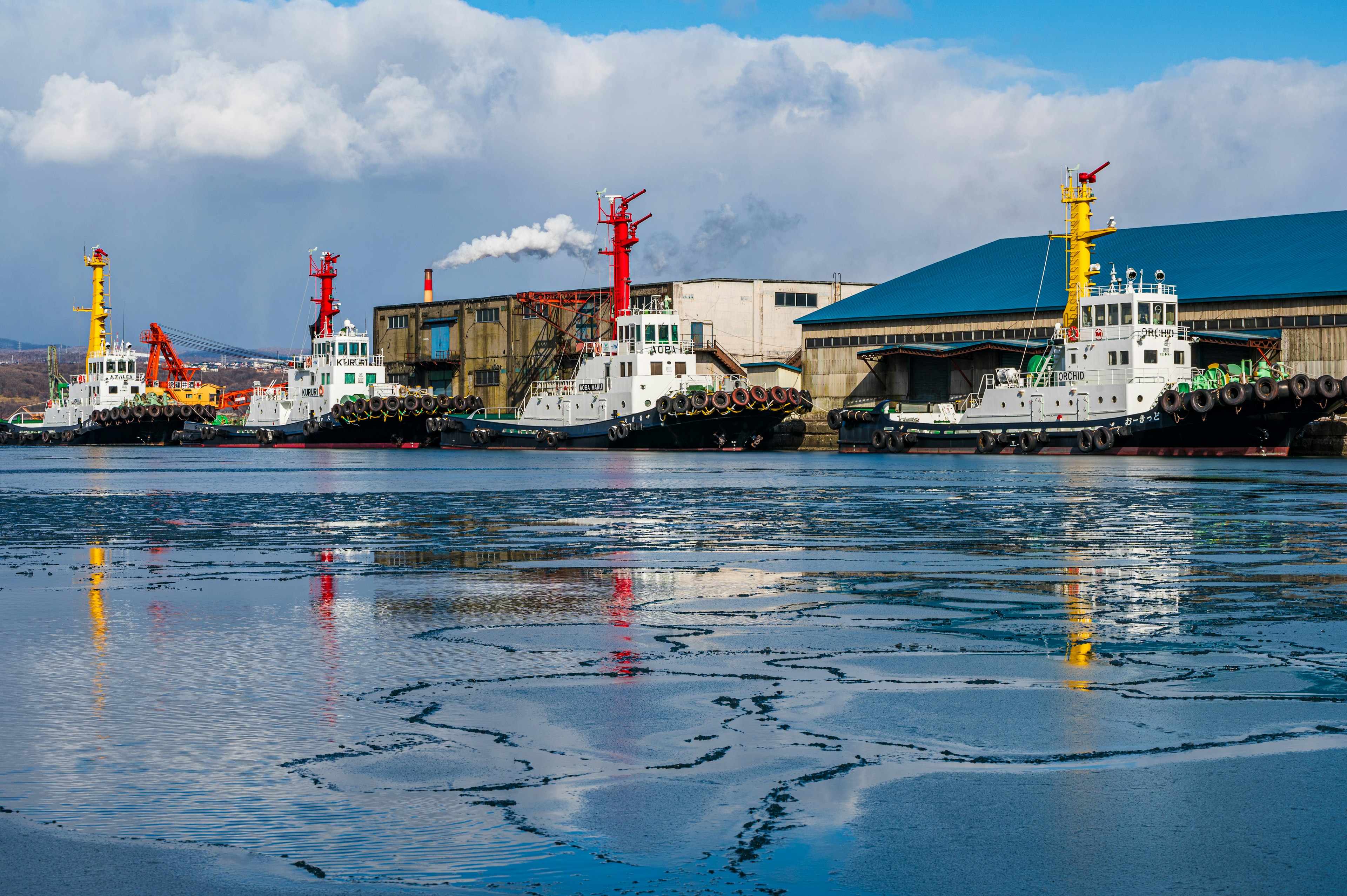 Schlepper im Hafen mit Eis auf der Wasseroberfläche