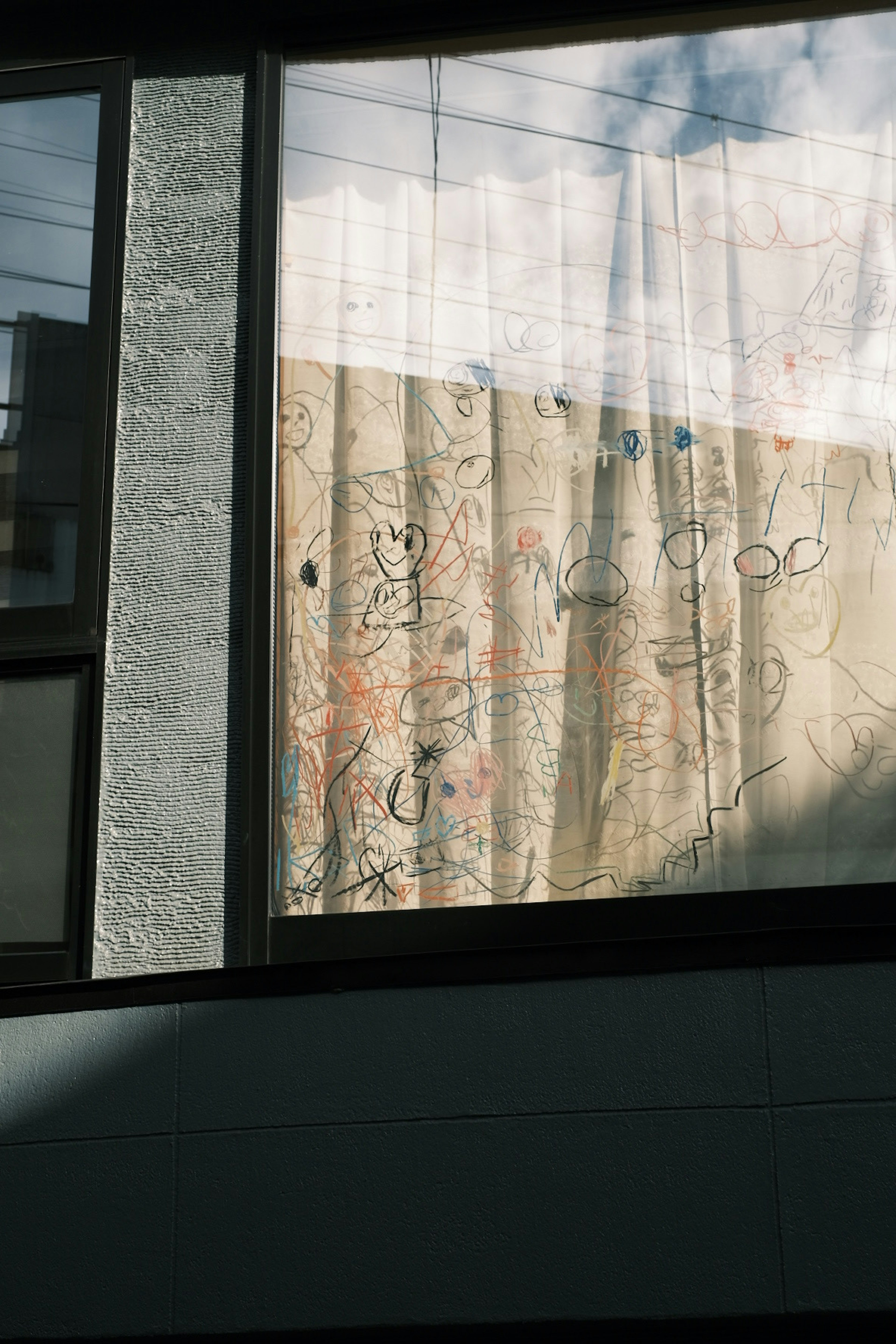 Softly patterned curtain seen through a window with natural light