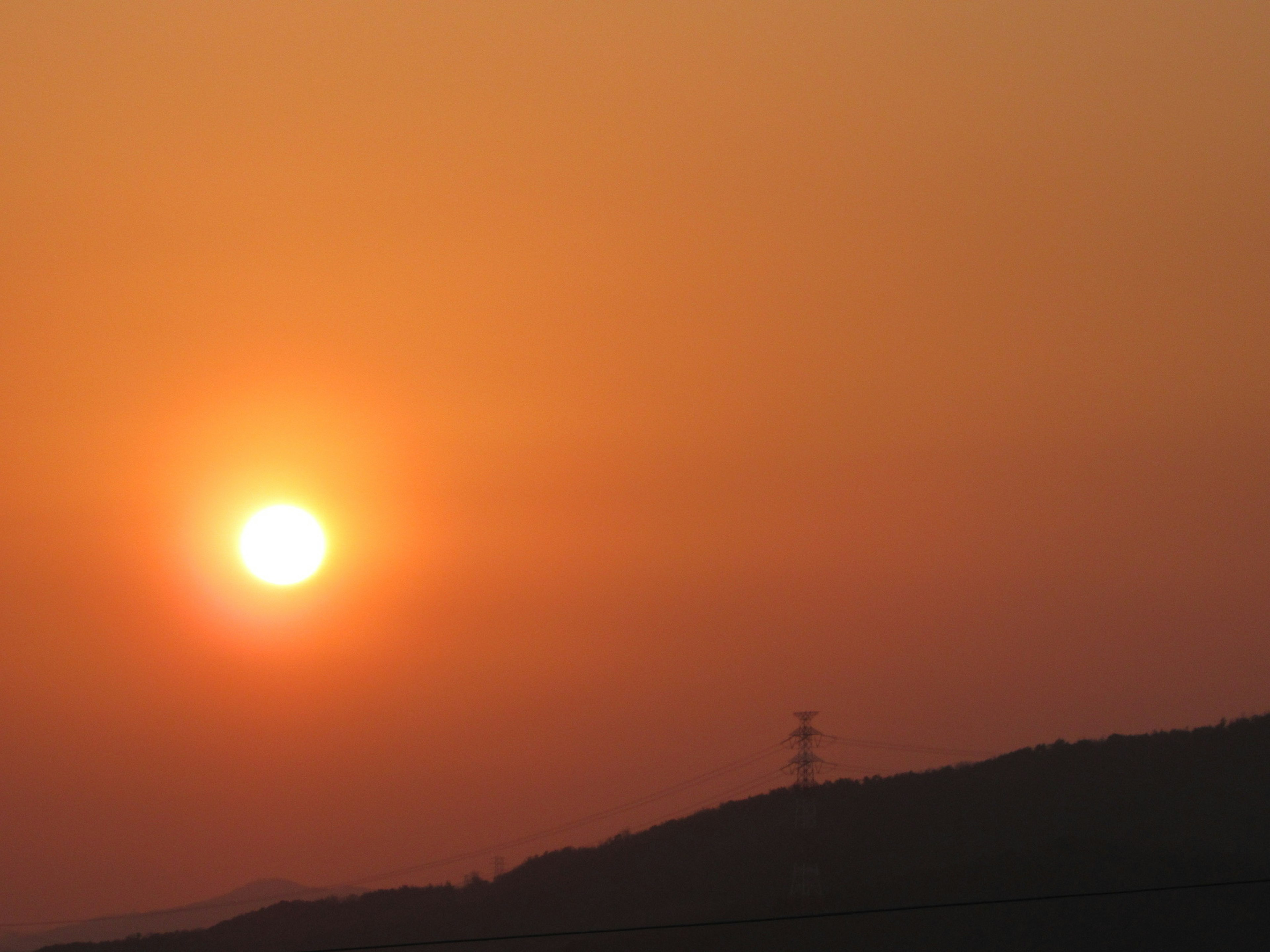 Oranger Sonnenuntergang über der Silhouette der Hügel